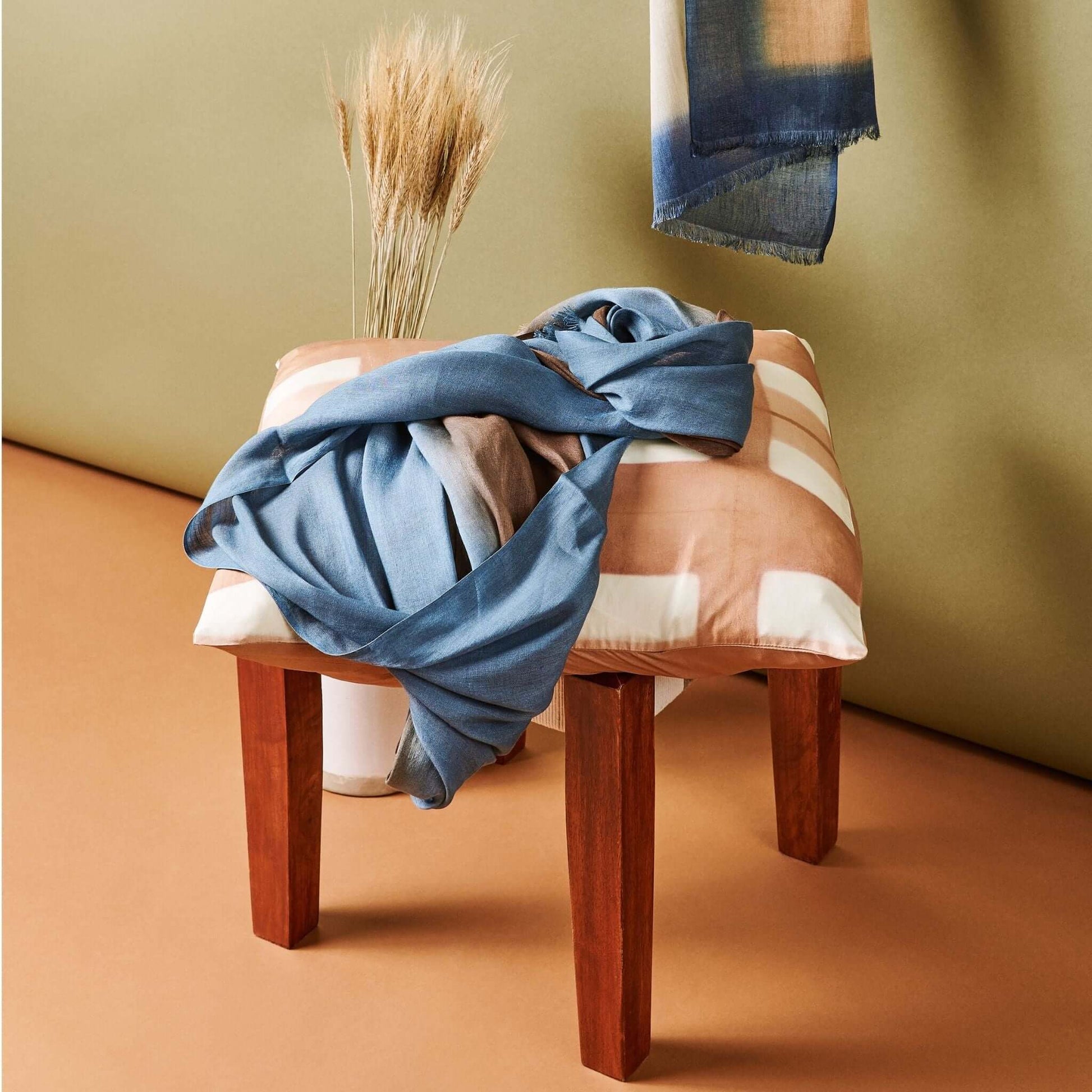 Mahogany Sky Brown Blue Ombre Linen Silk Handloom Scarf draped over a cushion with decorative dried flowers.