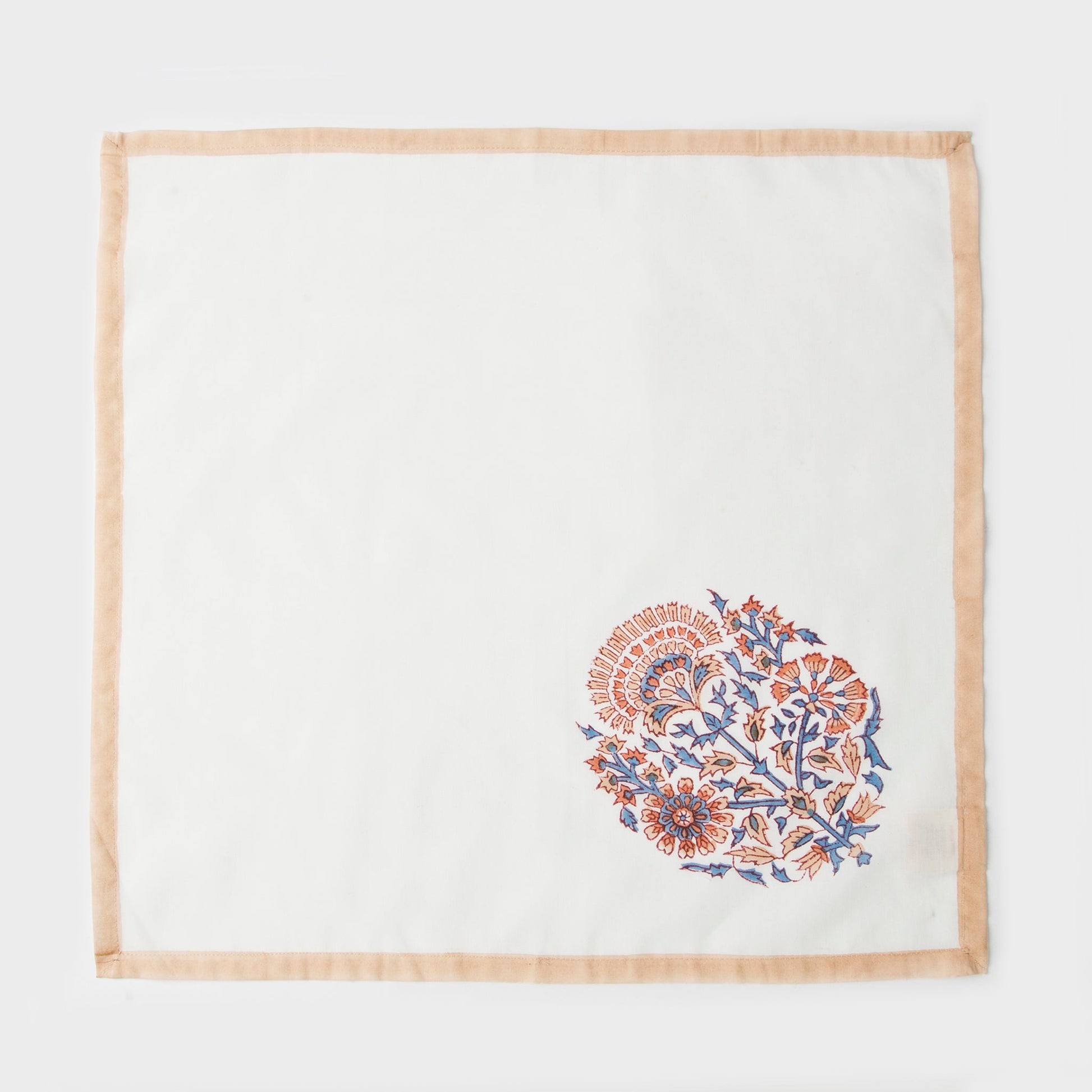 Close-up of artisan-crafted floral block print on soft ivory cotton fabric.