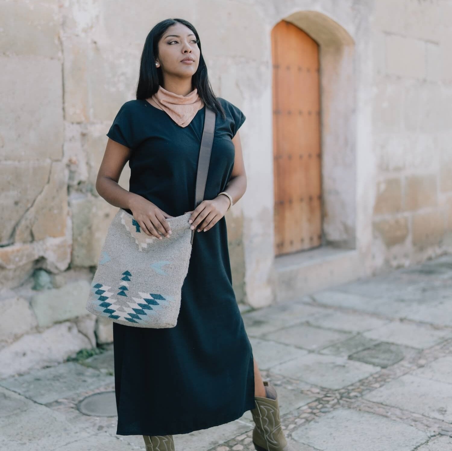 AMASOUK roomy handwoven wool Aguila Shoulder/Crossbody bag with a Zapotec pattern in blue, ivory, and honey on a gray backdrop. Ideal for any day-to-night occasion.