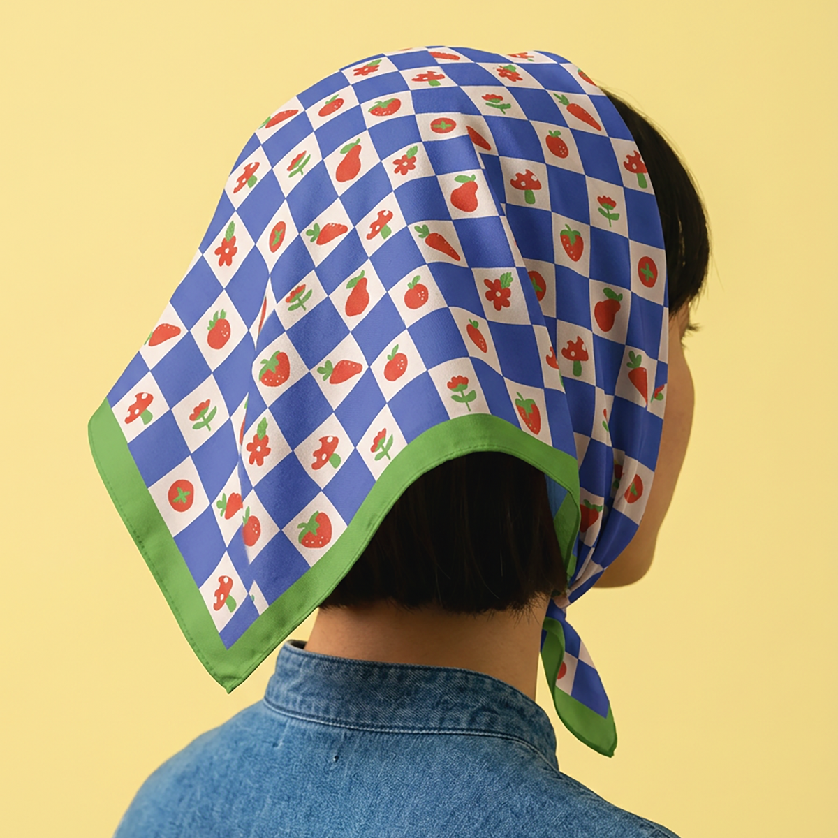 woman wearing head bandana with blue checkers and orange color fruits pattern, 100 cotton with green border.