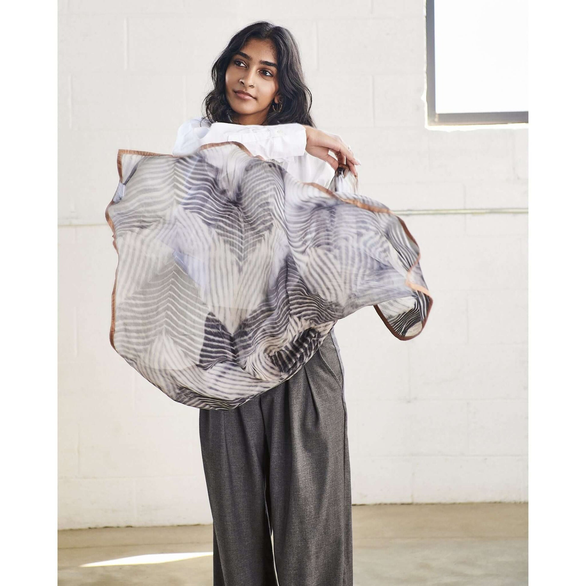 Model showcasing the Samu Black Hand Crafted Shibori Print Silk Chiffon Square Scarf in a stylish pose.