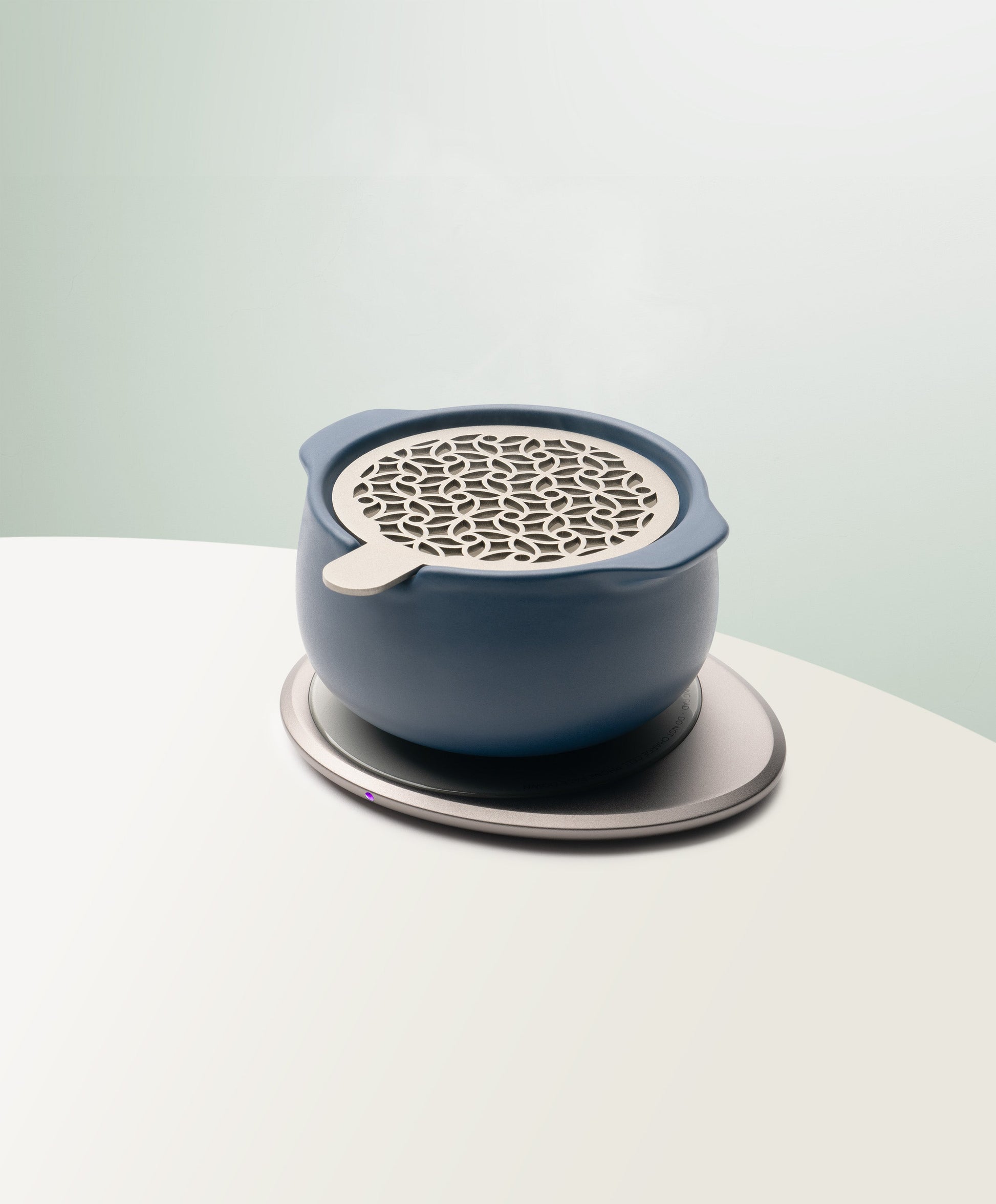 Jun Self-Heating Ceramic Diffuser 5 fl oz / 150 mL with lid in Deep Navy angled view on Ohom Pad 3