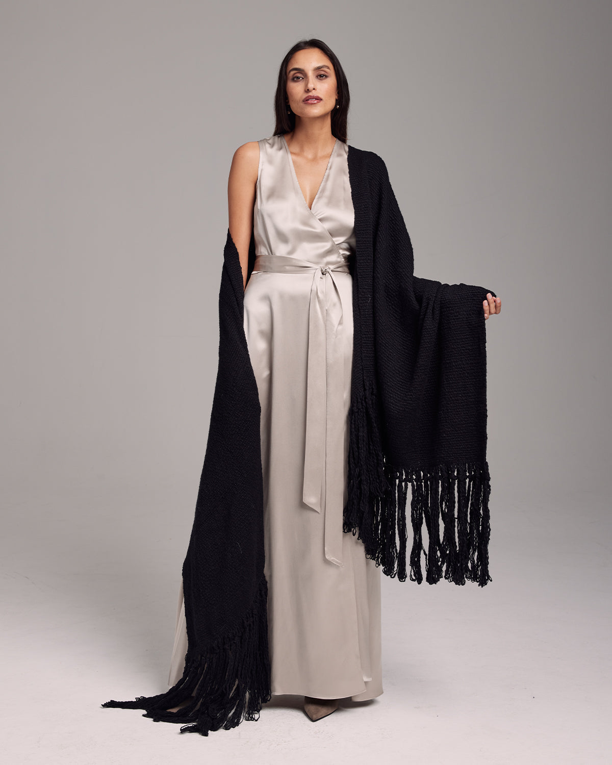 Model wearing a black Flammé Fringe Wrap shawl with fringes