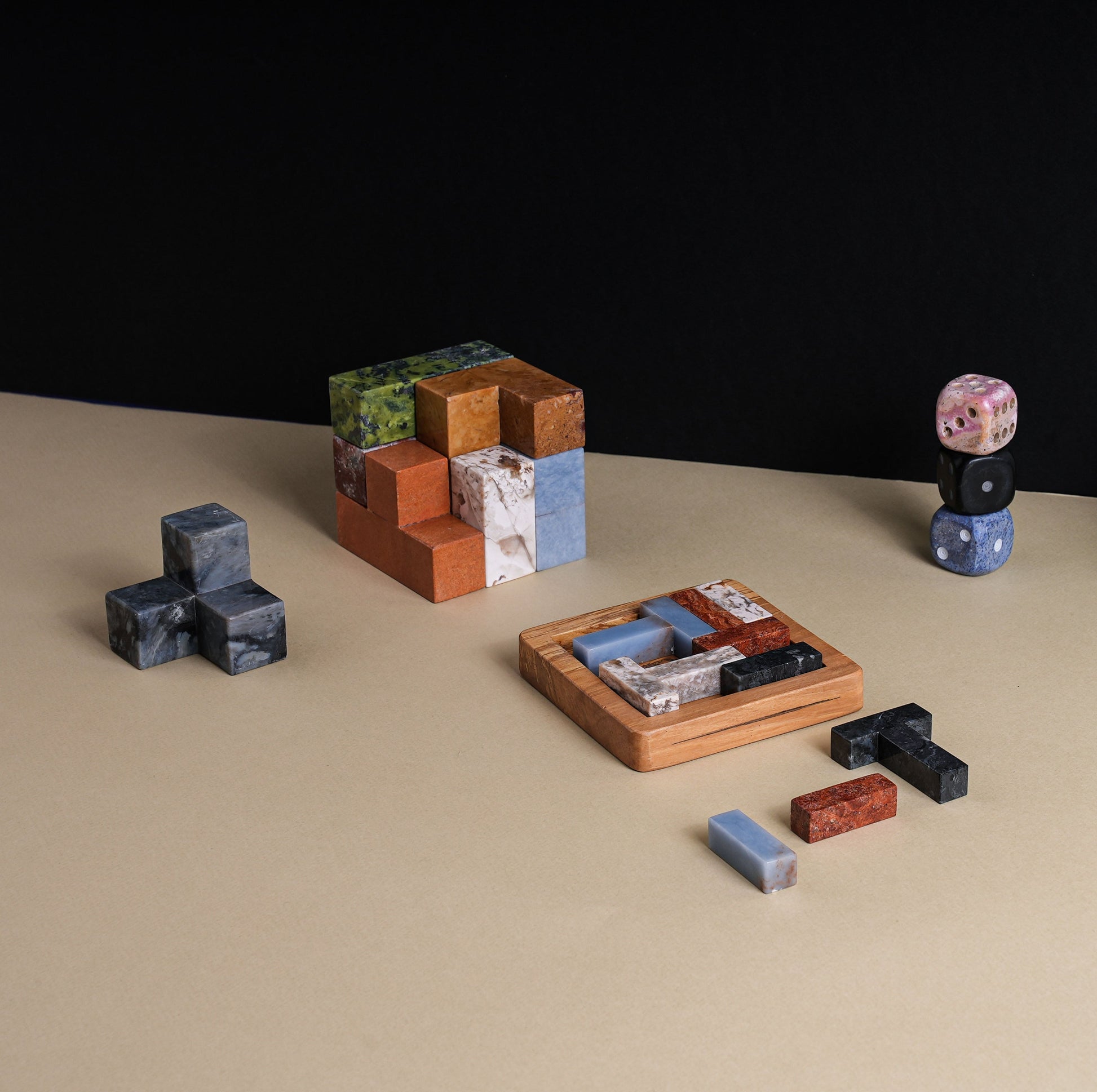 Multi-stone gemstone puzzle displayed as an elevated artistic object in a quiet luxury setting.