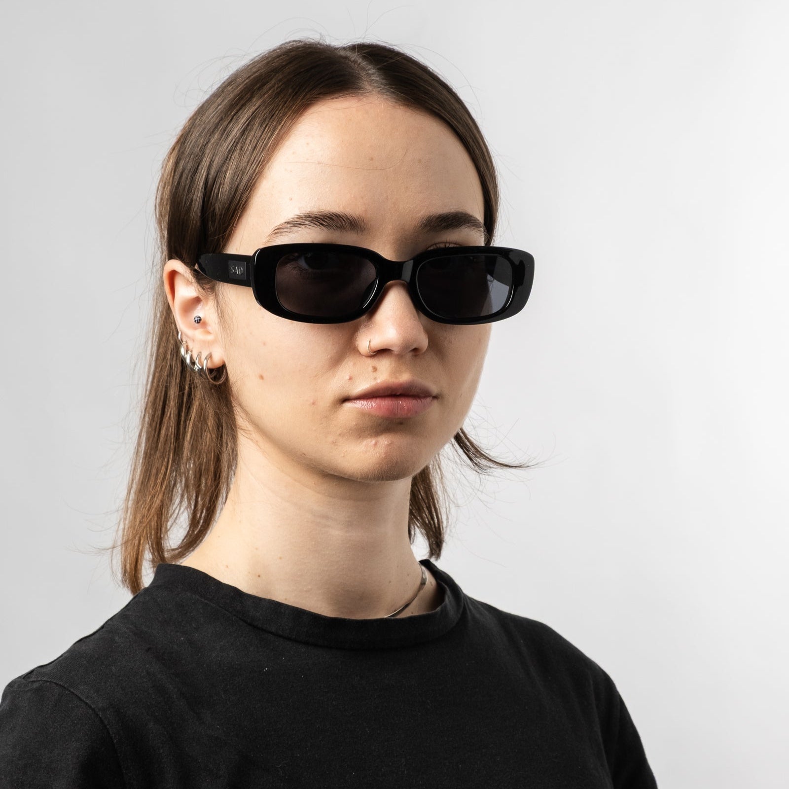 Female wearing Sad Eyewear Bouquet rectangle sunglasses in gloss black with black tinted lenses