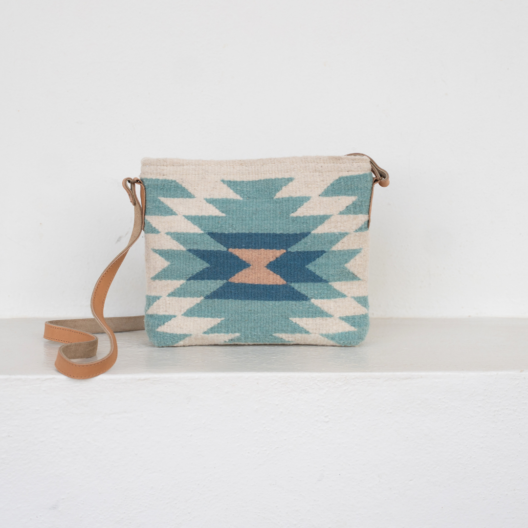 Handwoven crossbody bag with abstract Zapotec diamond design in soft spring tones; features adjustable leather strap and two internal pockets for daily essentials