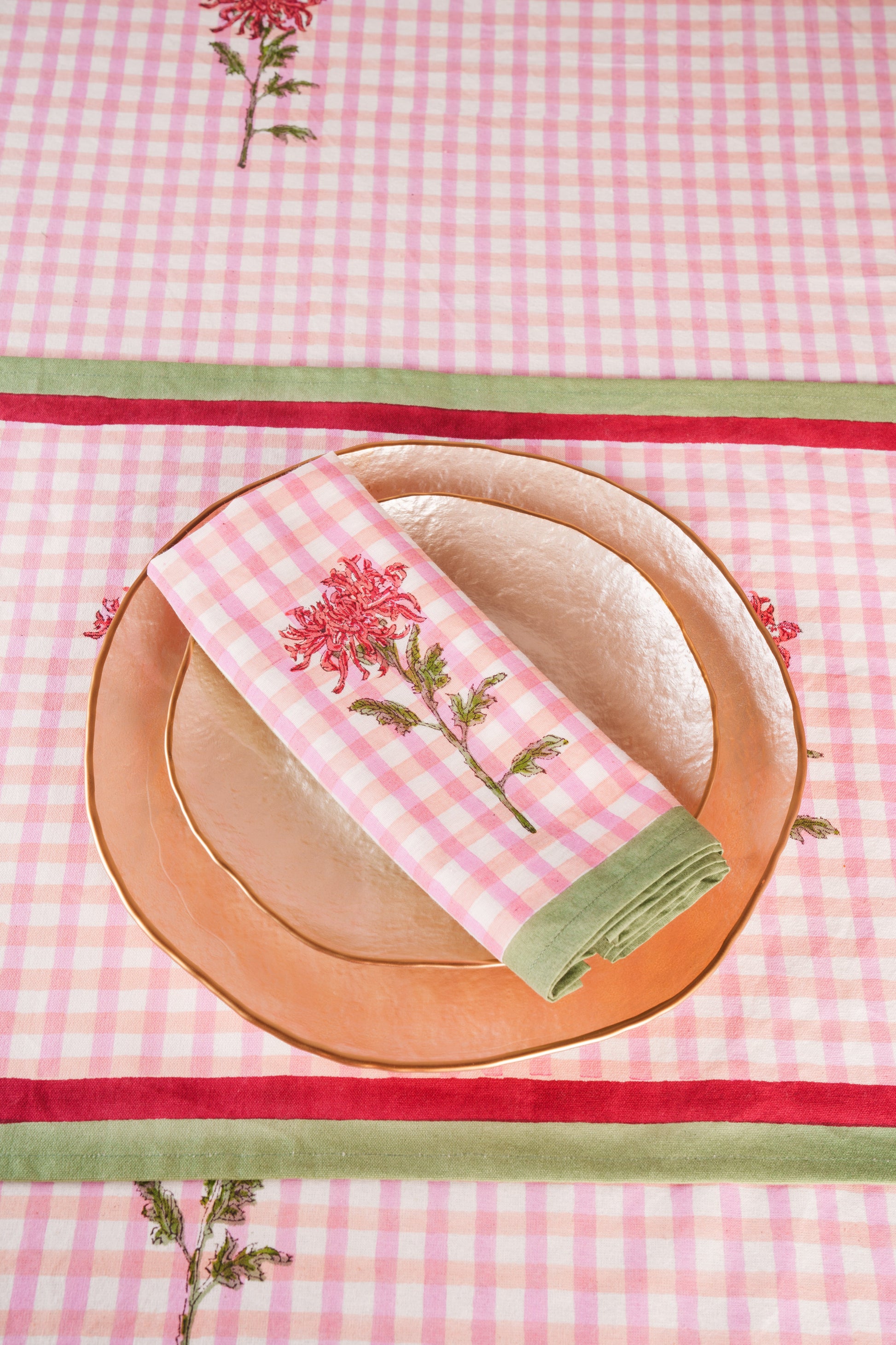 Pink gingham napkins with dahlia flower print, set of 4, on copper plates