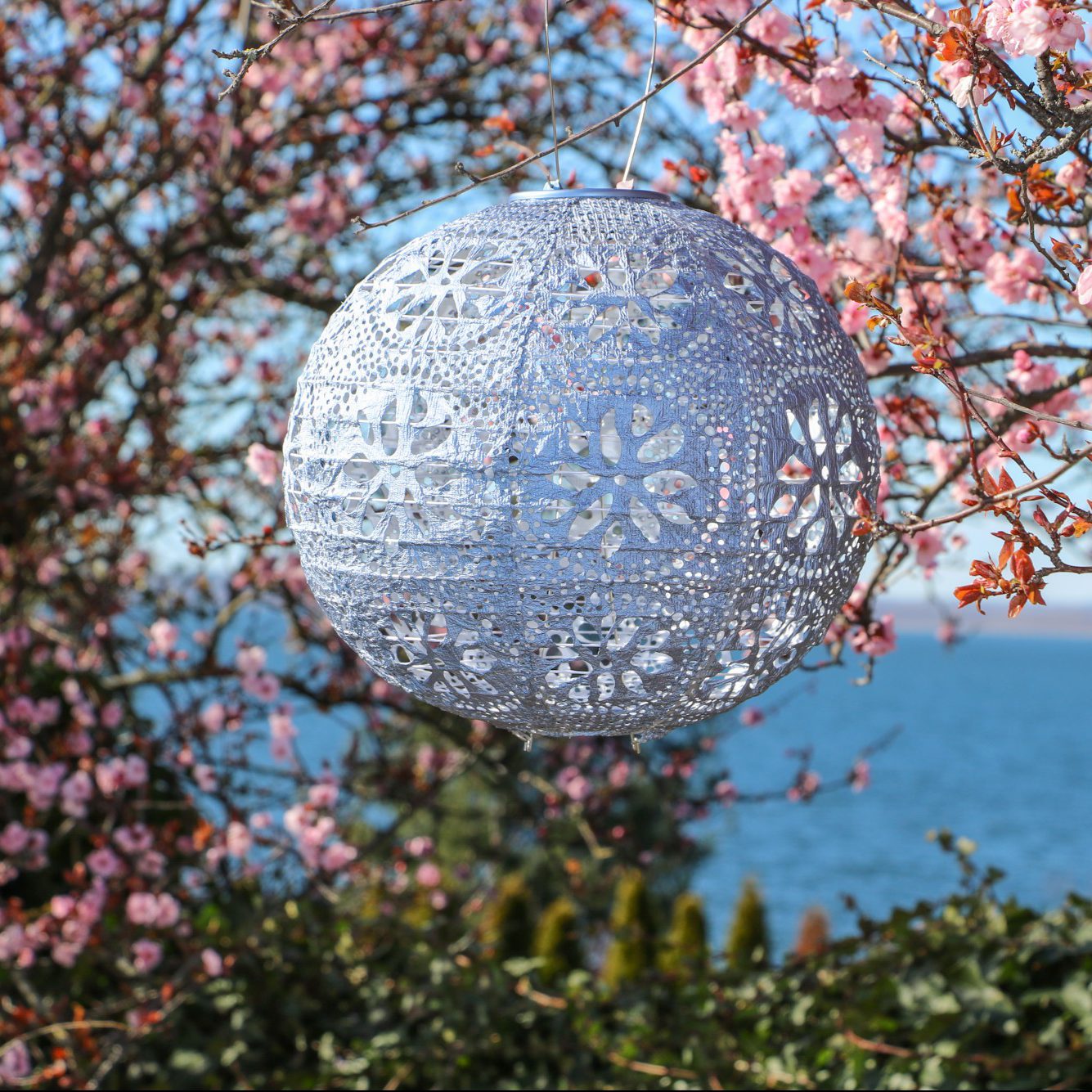 Soji Stella Boho Tyvek Solar Lantern in tree with blossoms