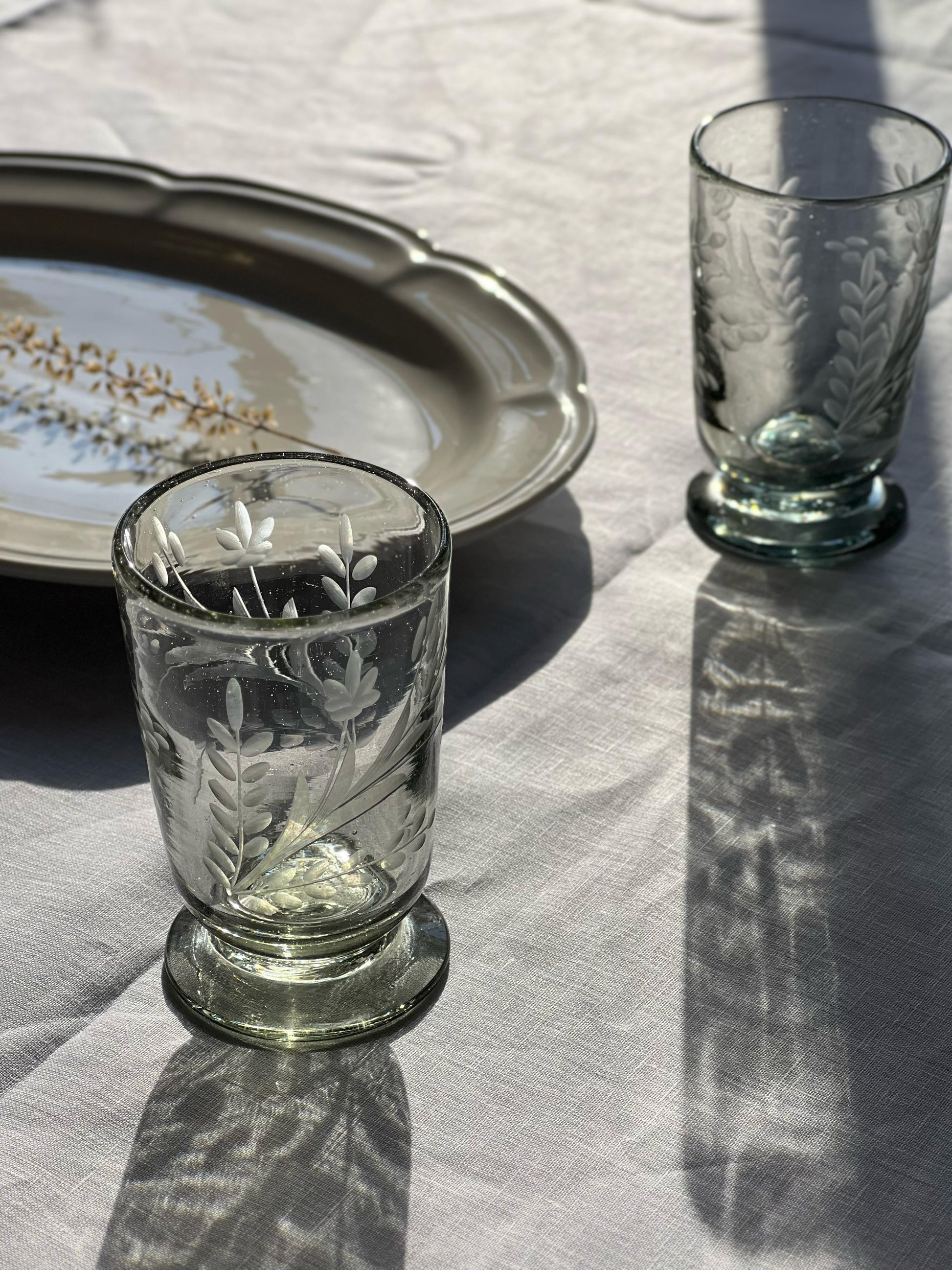Hand-etched blown footed glass made from recycled glass with floral design, ideal for serving water, wine, or tea
