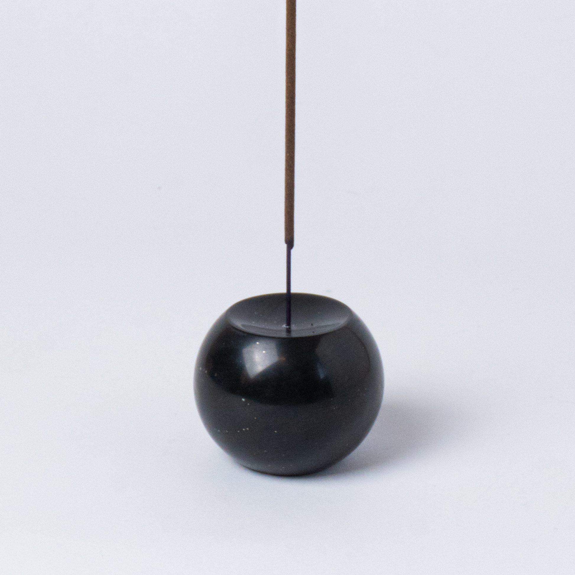 Close-up view of the black onyx gemstone sphere incense holder highlighting its smooth, dark finish on a white background.