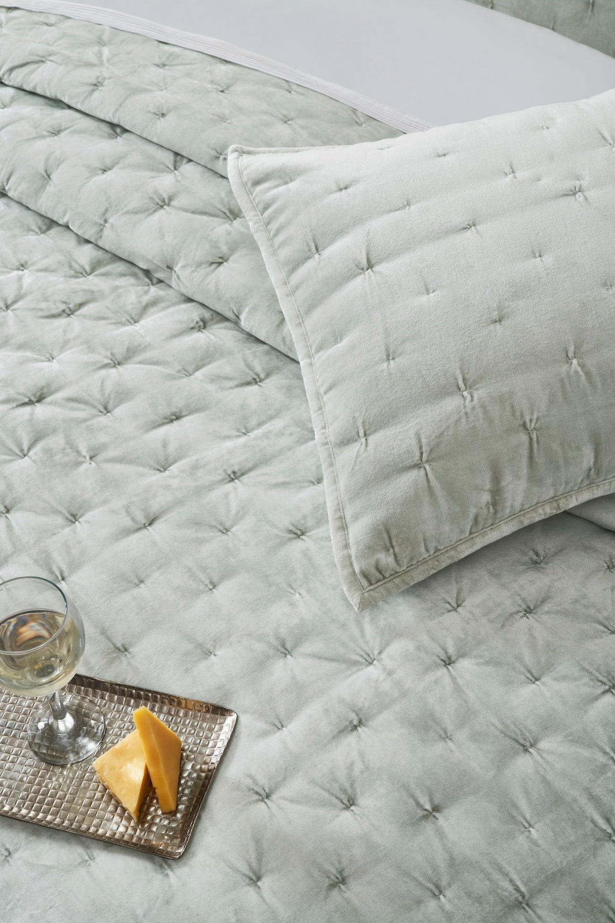 QT-371-9496_4|Overhead view of a soft sage green velvet quilt with uniform square tufting, cozy and inviting for relaxation.