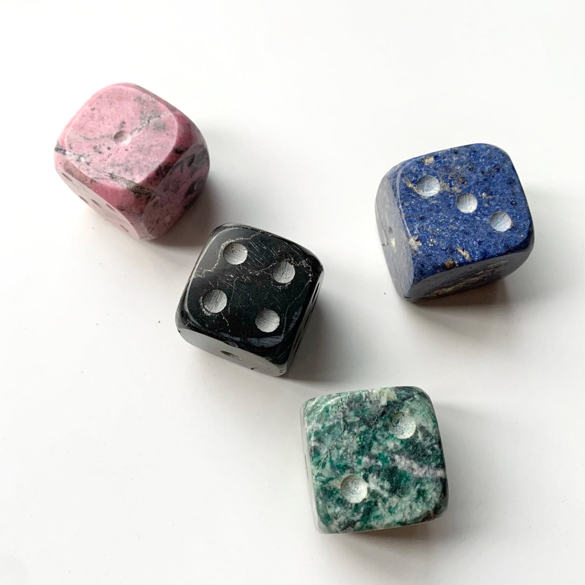 Complete set of 4 giant natural stone dice aligned on a white background.