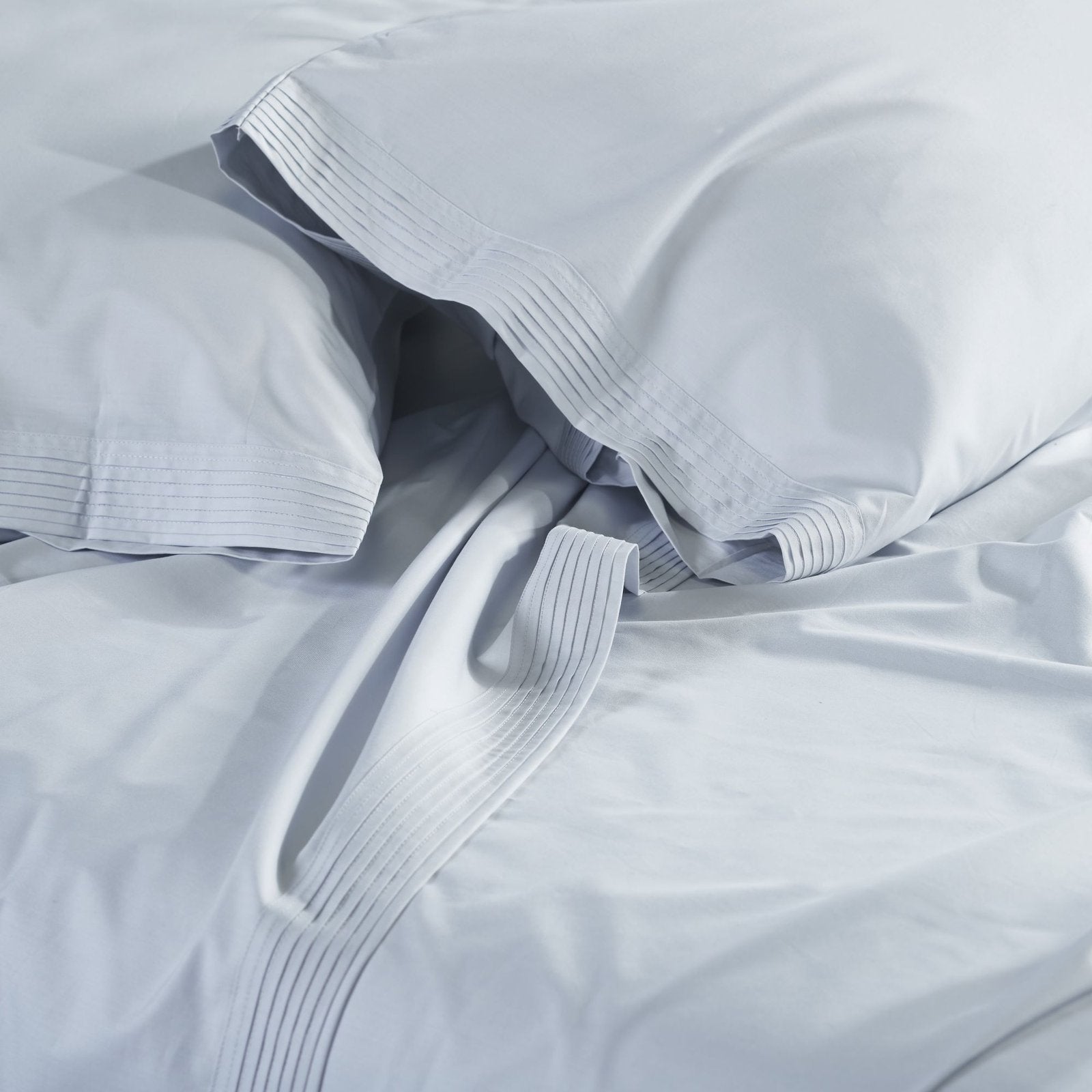 QSS-524-6080_3|Close-up of soft light blue 100% cotton sheets, showcasing crisp pleated borders and luxurious, breathable fabric.