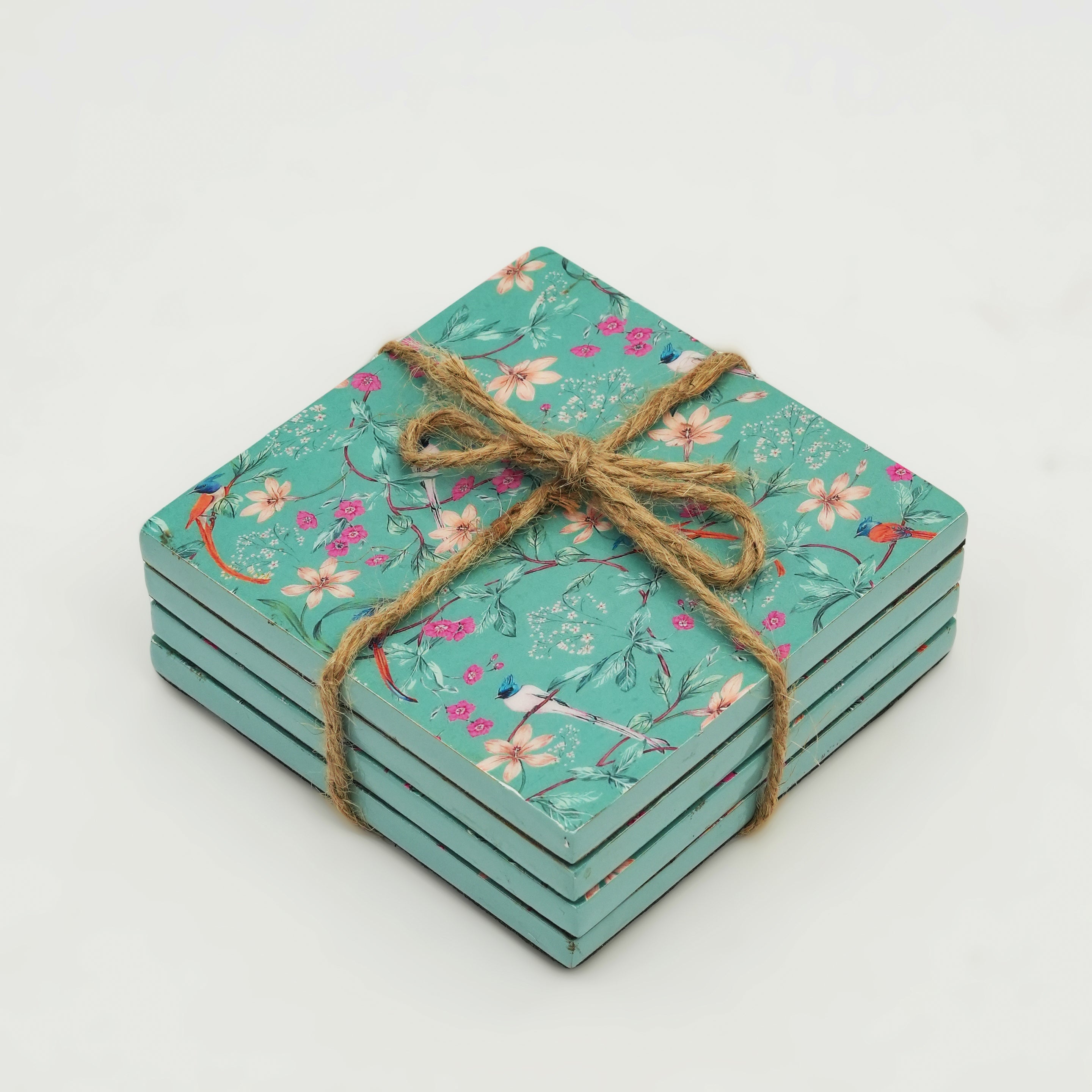 Set of floral coasters tied with twine on a light gray background