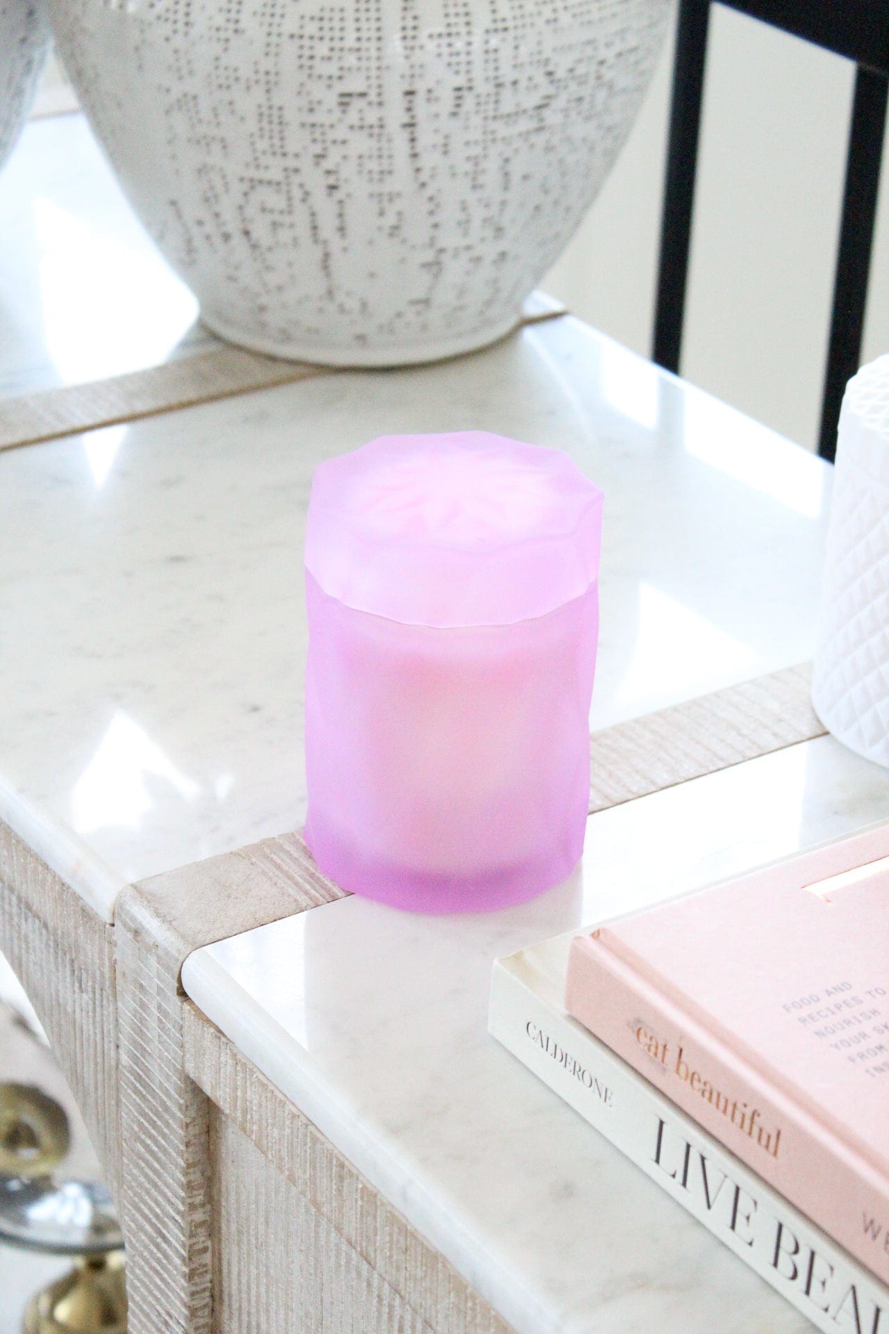 lavender lilac color glass jar with lid on a marble side table