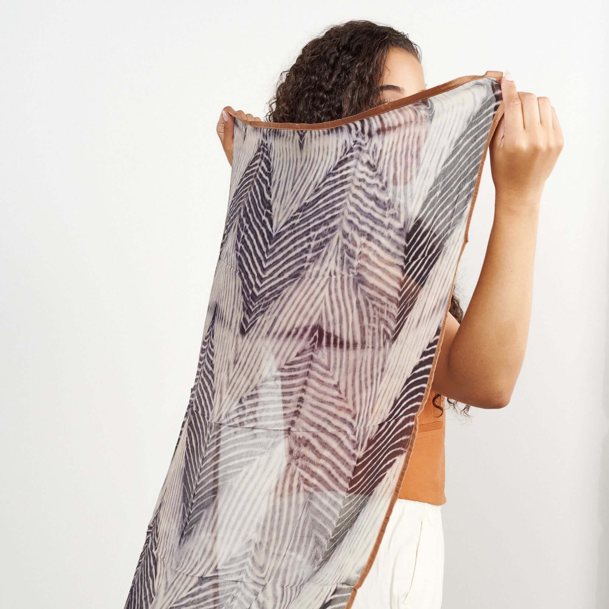 Chiffon square scarf Samu Black held by a woman showcasing its elegant shibori print design.