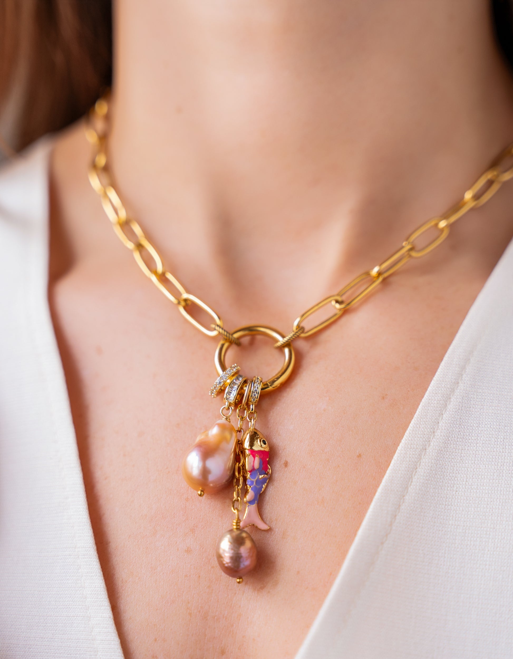 Gold chain necklace with freshwater pearl and colorful charm cluster pendant.