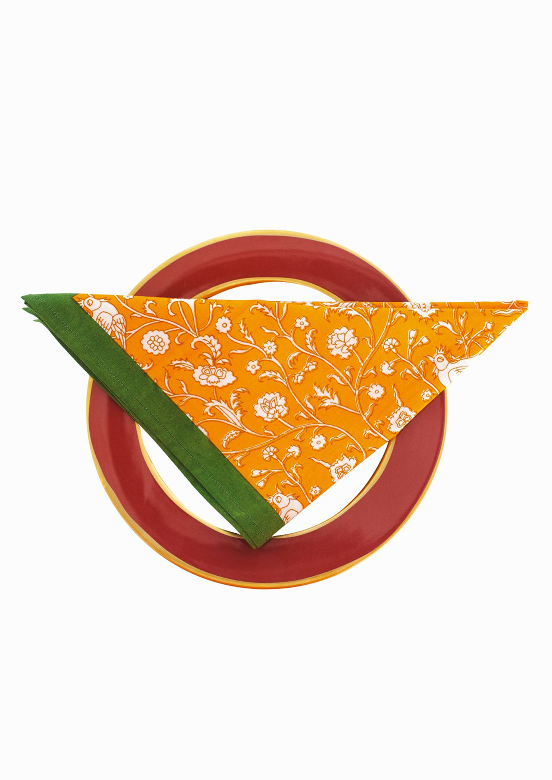 Folded orange blockprint napkin on red decorative plate from Inner Child