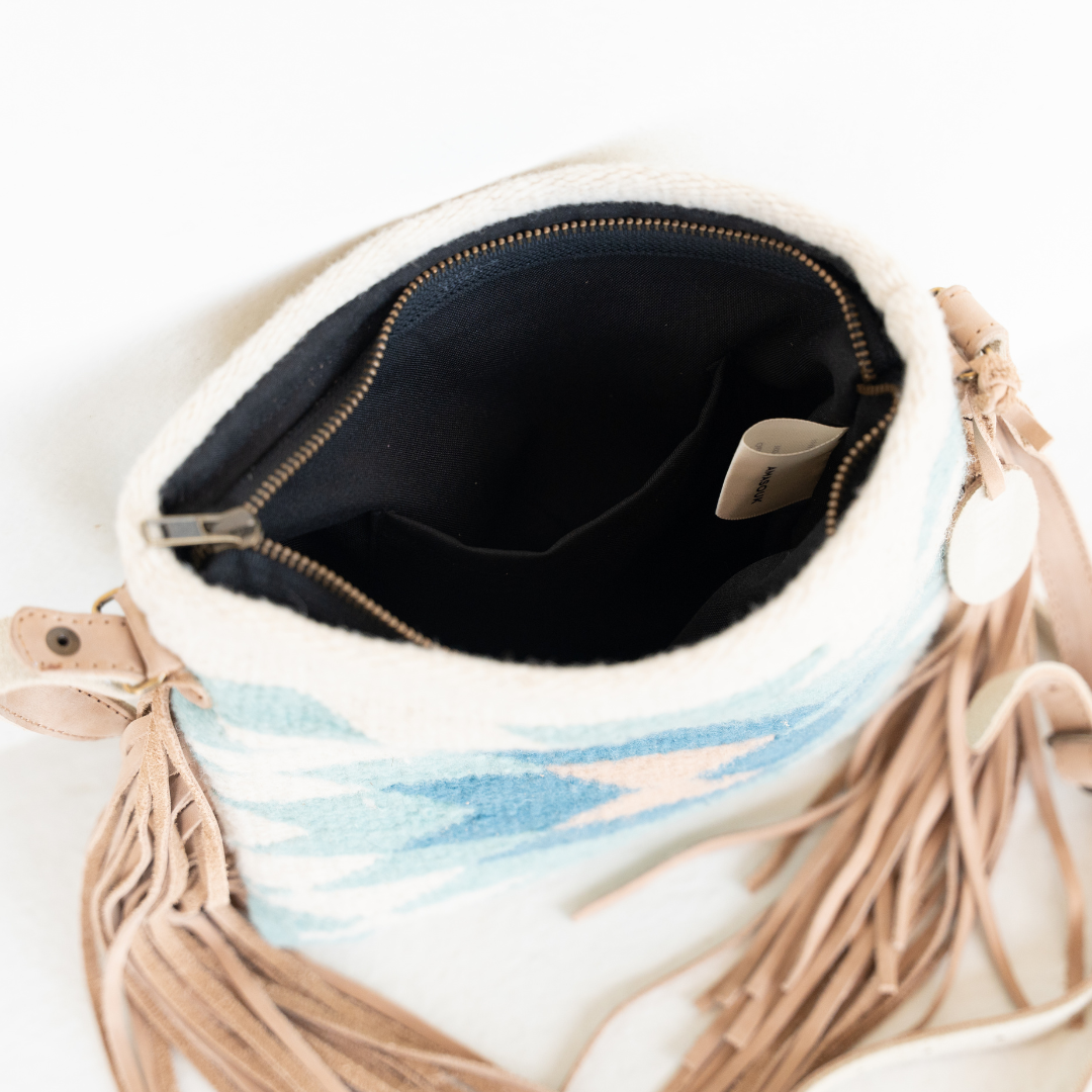 Handwoven fringe crossbody bag with abstract Zapotec diamond design in soft spring colors; features adjustable leather strap and two internal pockets