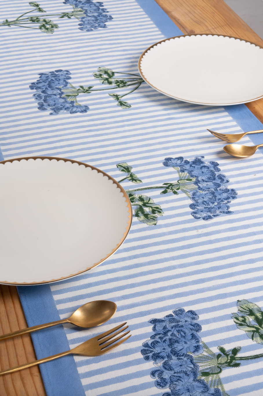 Blue Hydrangea Tablerunner with blue/white stripes, gold-rimmed plates on wooden table