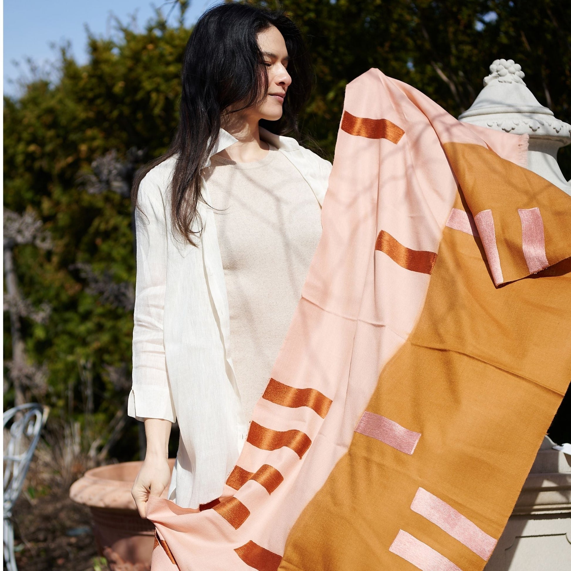 Canyon Orange Hand Embroidered Hand Woven Merino Blend Scarf showcased by a model outdoors in soft natural light.