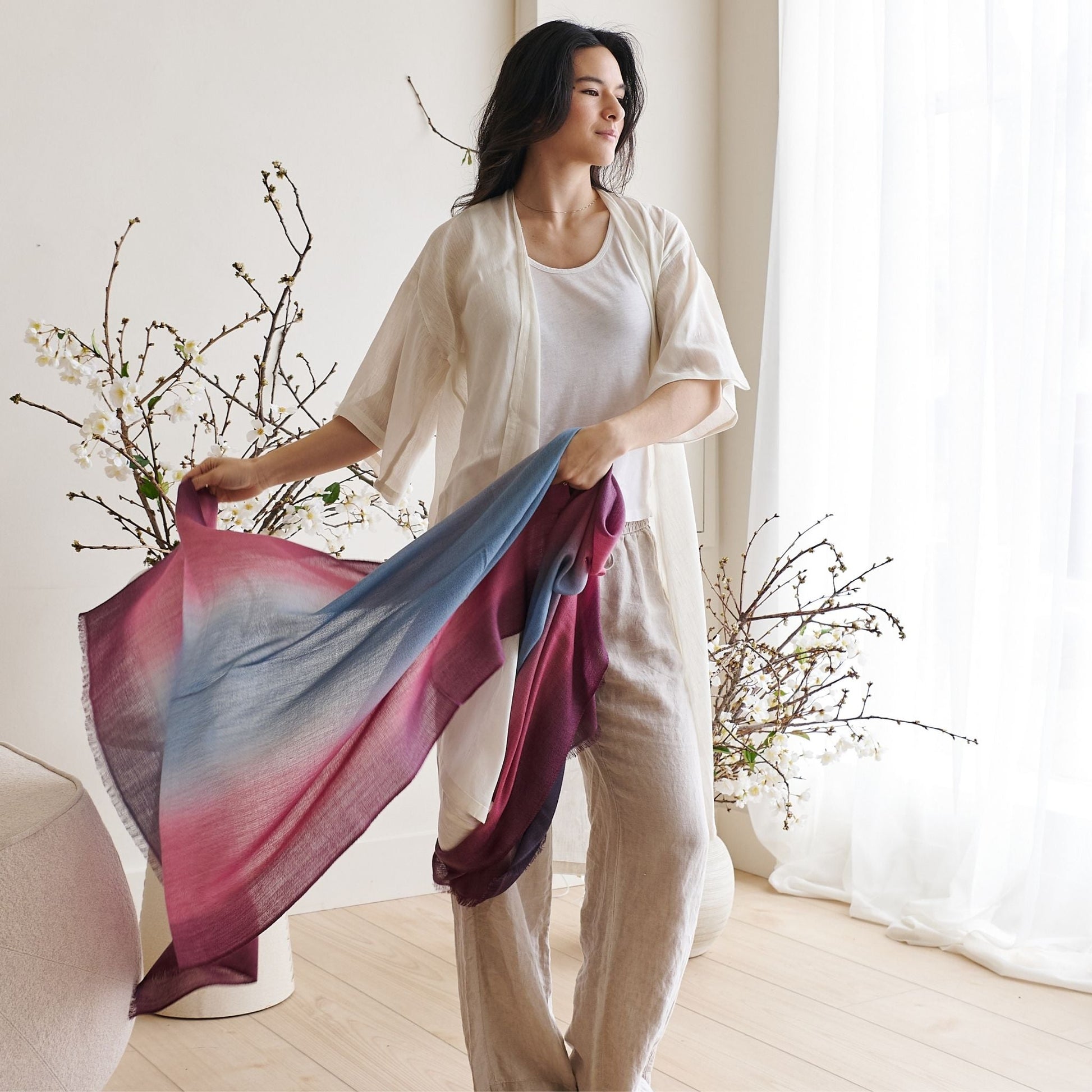 Iris Haze Blue Pink Cashmere Merino Handloom Scarf showcased by a model in a bright, elegant setting.