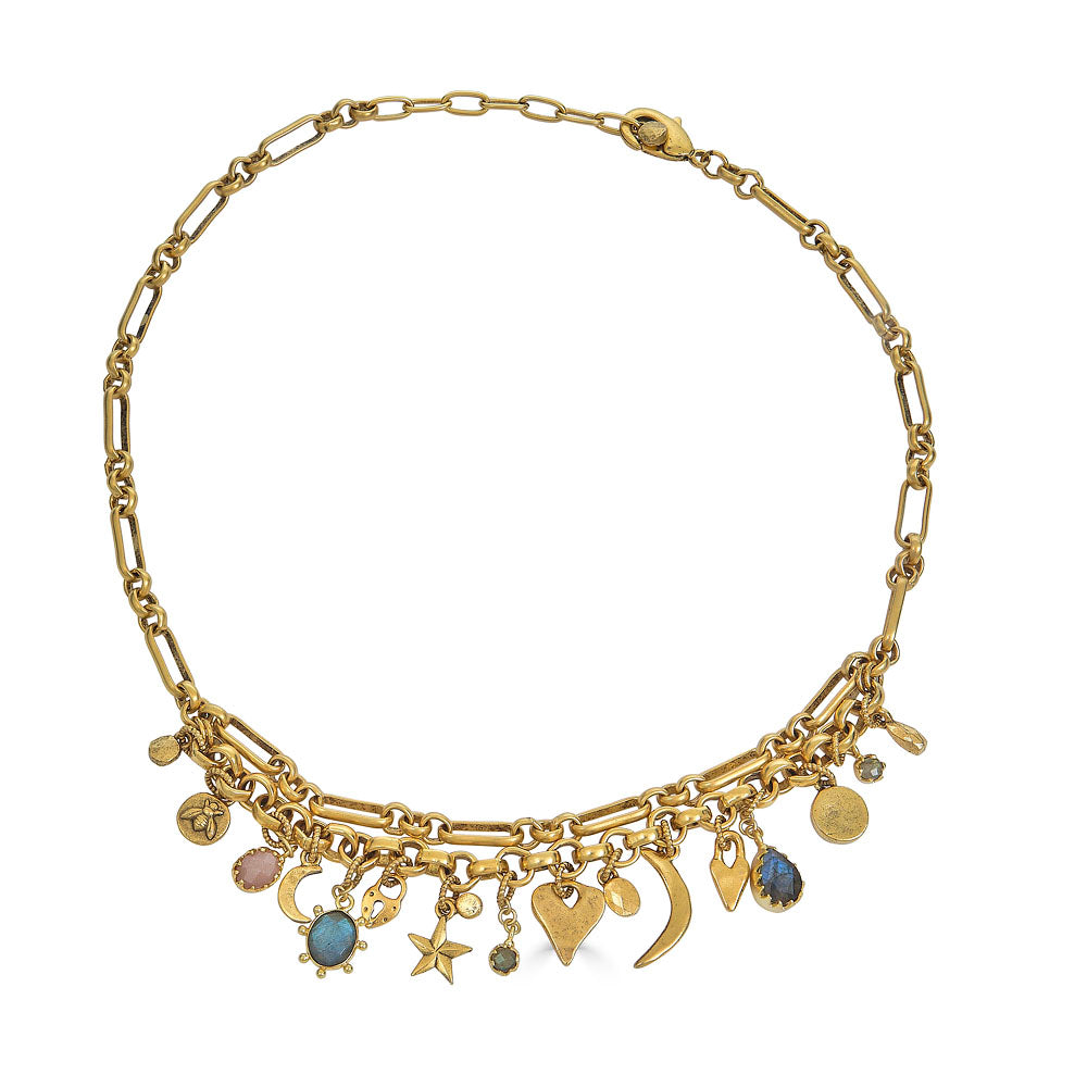 Gold charm necklace with layered chain and assorted symbolic charms including moons, hearts, stars, and gemstones.