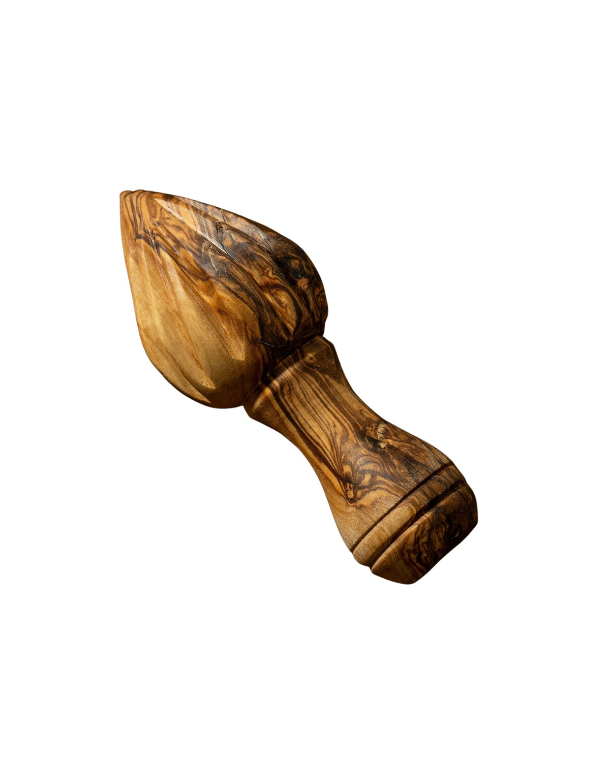 A wooden lemon press with natural olive wood patterns, lying on a brown surface. 