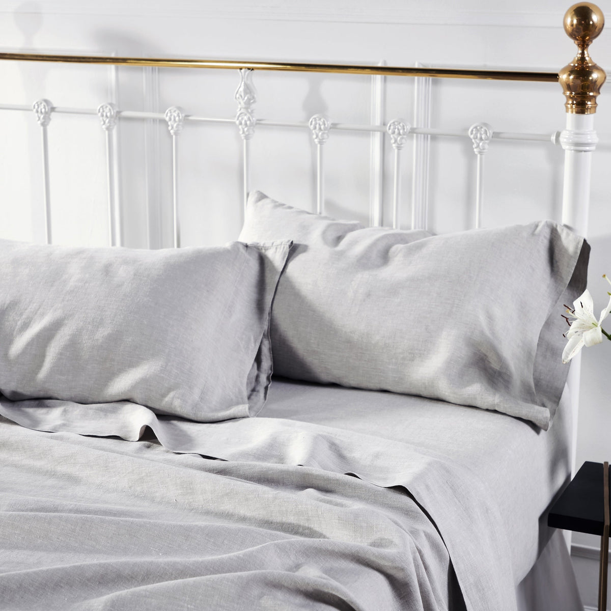 CSS-516-7284_3|Soft light grey 100% linen sheets and pillowcases on a bed with a white headboard, promoting comfortable, breathable sleep.