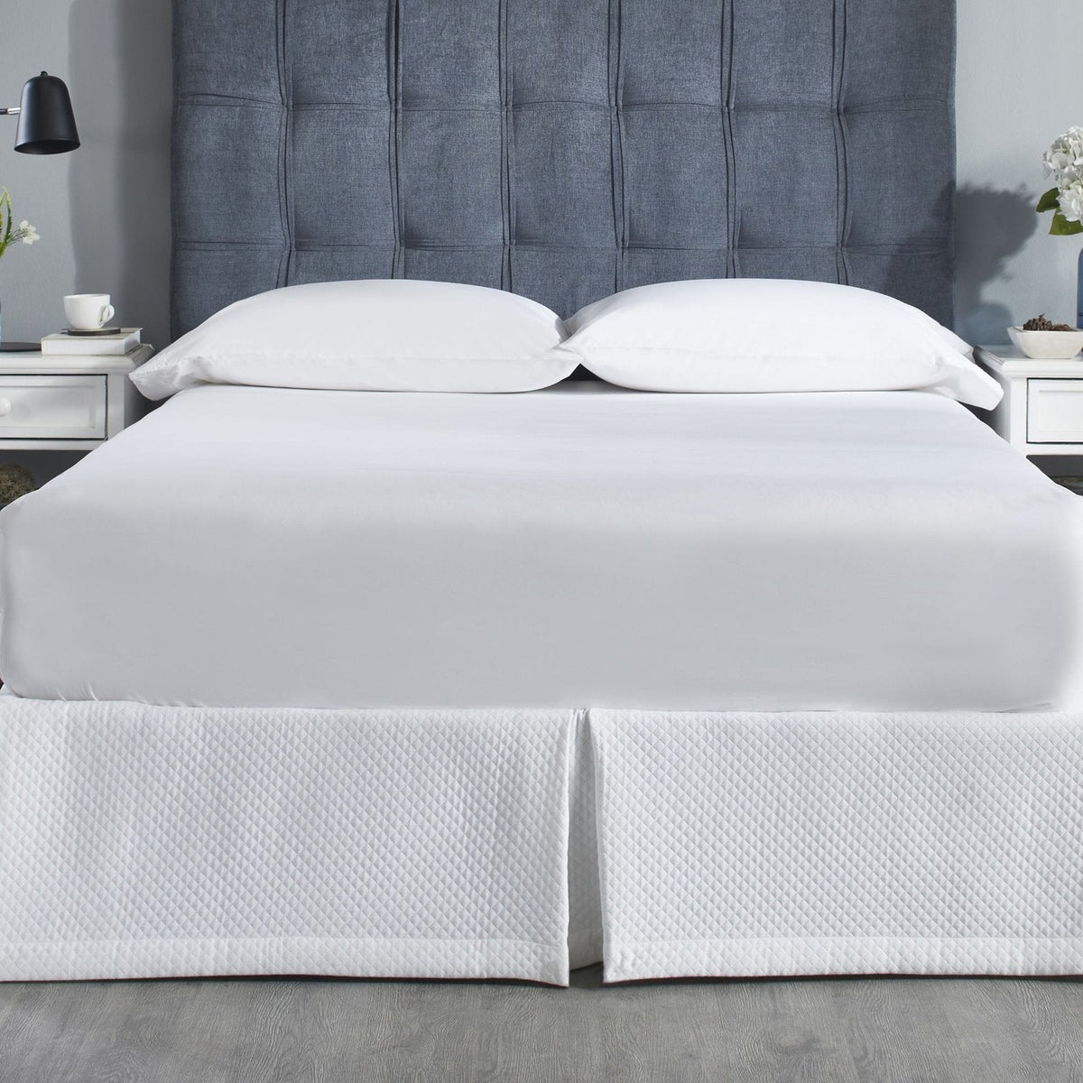 BS-117-X_1|White quilted bed skirt with diamond pattern on a bed, paired with crisp white sheets for a clean bedroom look.