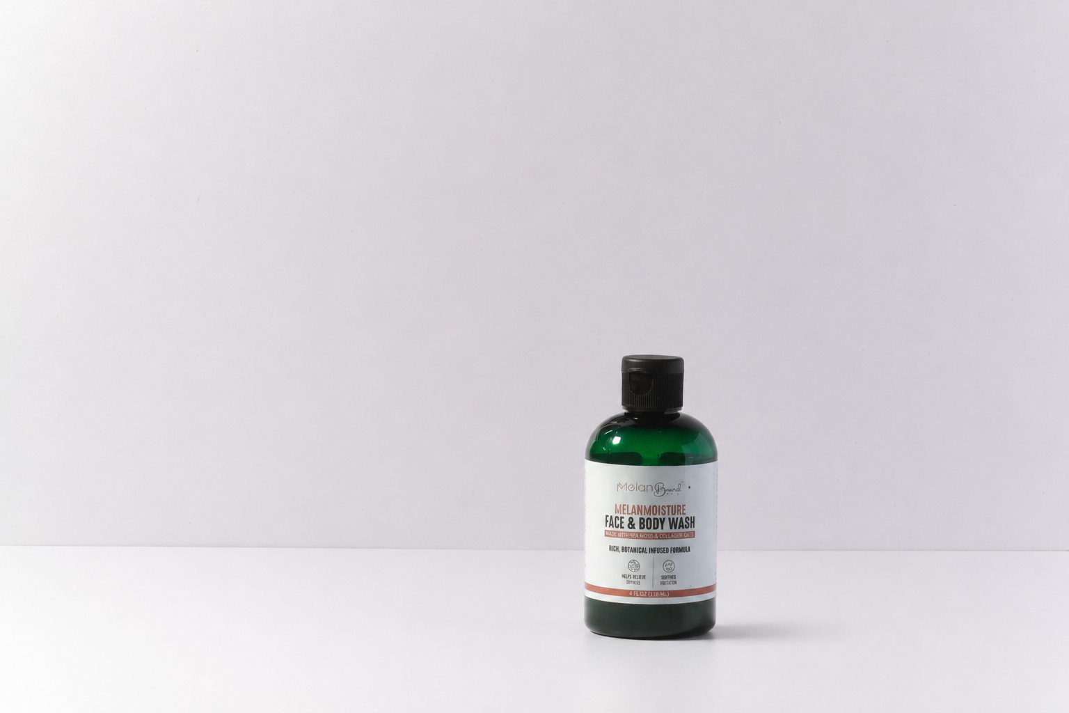 Bottle of Melano Moisture Face & Body Wash surrounded by bath items on a soapy background