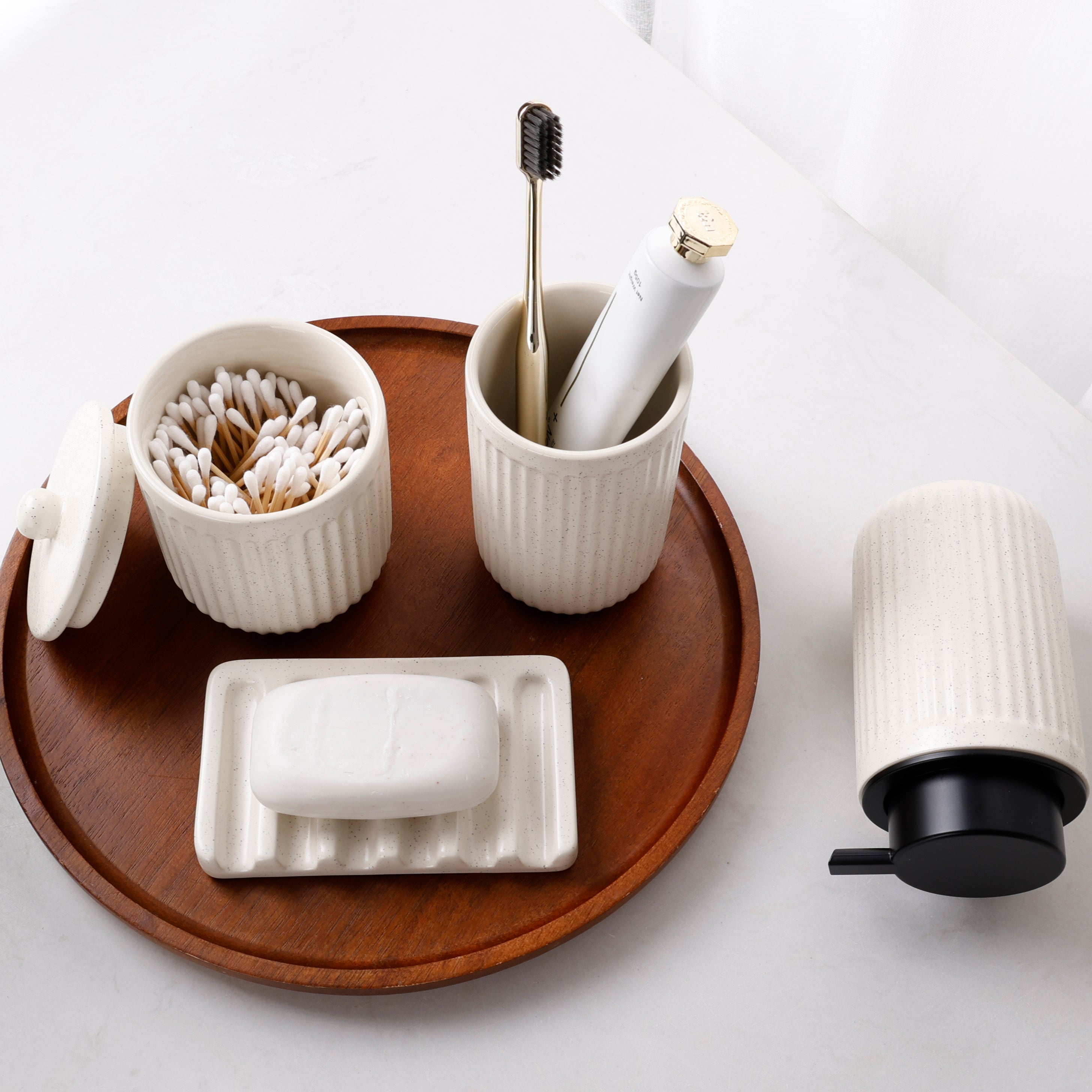 Overhead lifestyle view of the beige BosilunLife Pockmark recycled eco-clay 4-piece foaming bathroom set arranged on a wooden vanity tray.