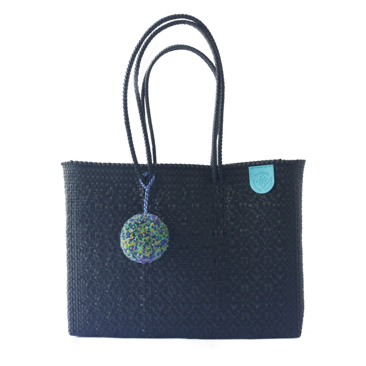 Tin Marin super tote in All Black Design, A black  oversized tote bag with a pompom decoration, and a shoulder strap.