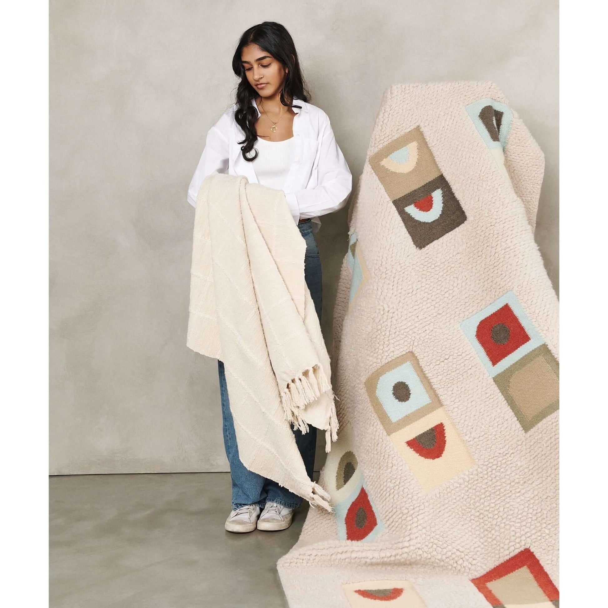 A model holding the Sea Shell White Textured Checks Handloom Throw, showcasing its elegant texture and design.