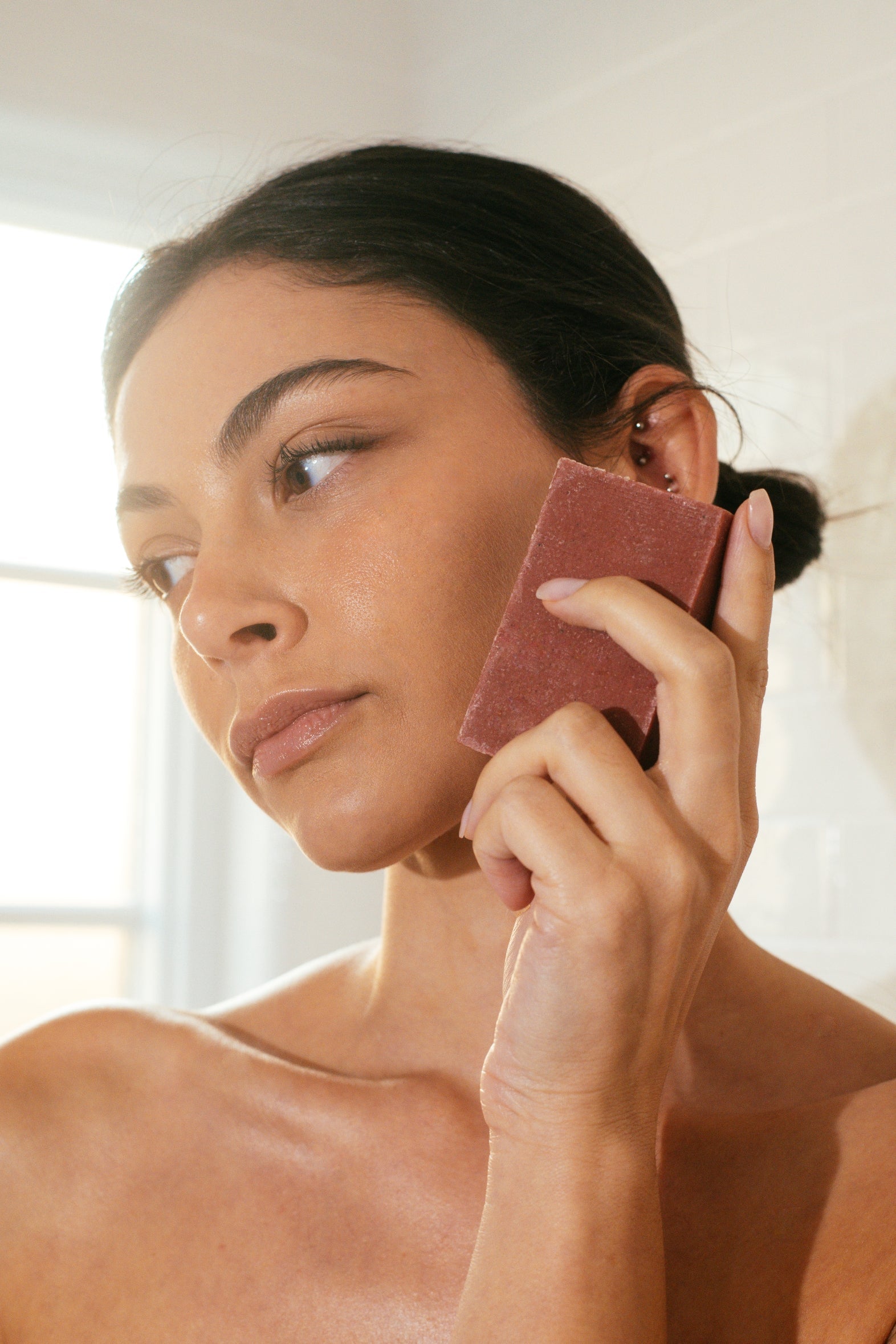 Woman holding Wenjulan Whole Body Care Sensitive Skin Cleansing Soap with Kaolin Clay bar against face