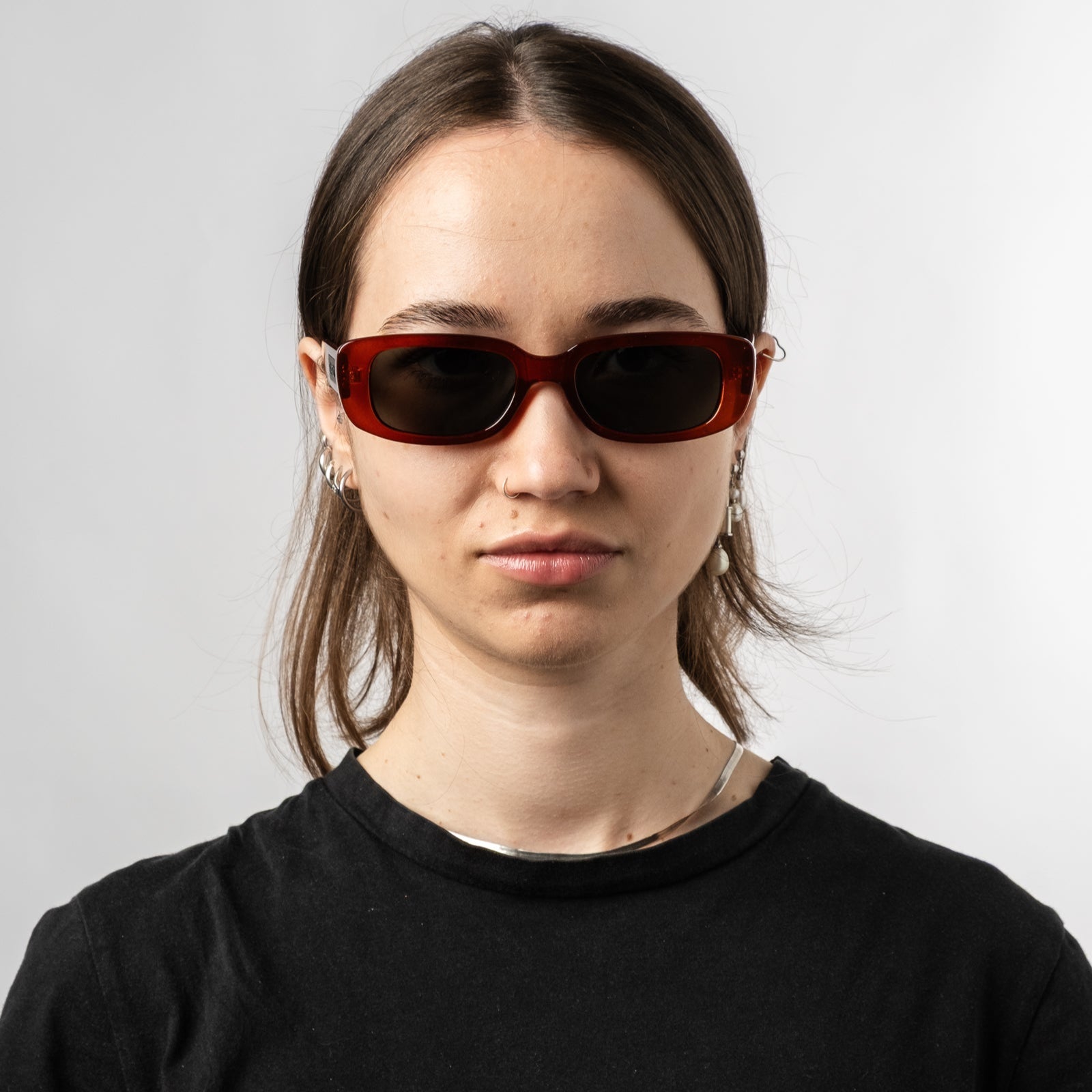 Female wearing Sad Eyewear Bouquet rectangle sunglasses in blood red with black tinted lenses