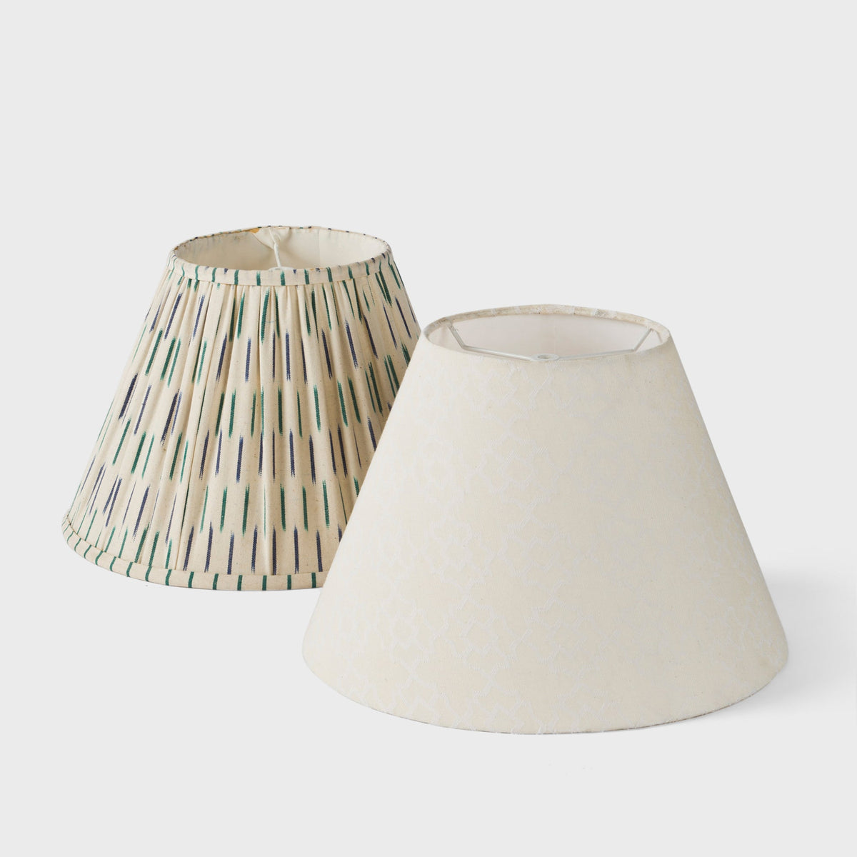 Angled view of both lamp shades highlighting the tapered shape and fabric textures.