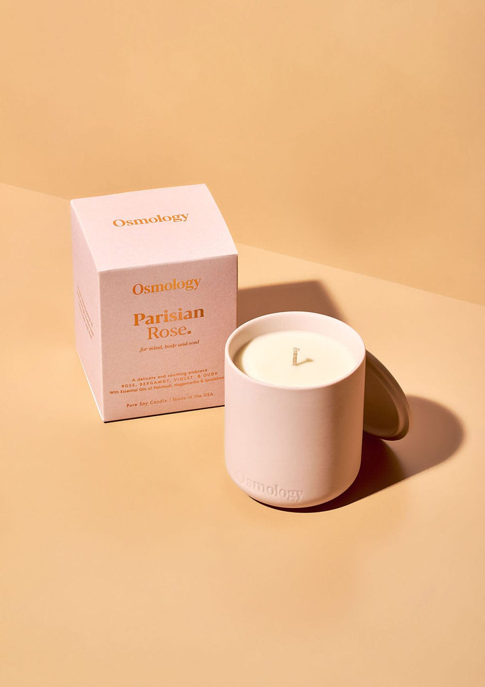 osmology pink ceramic candle next to box packaging