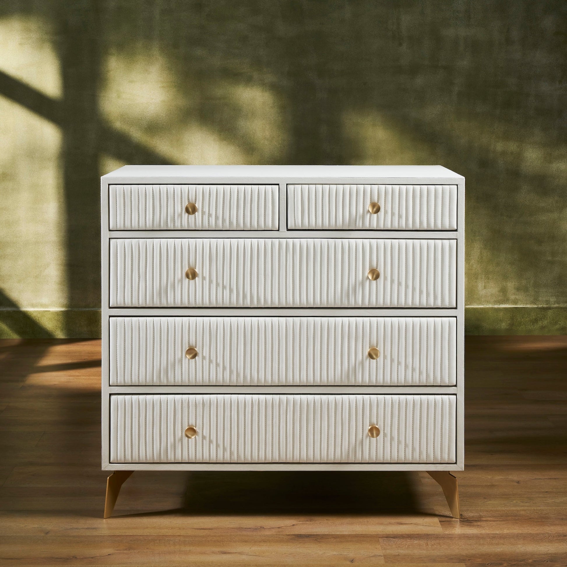 FN-5216-482036_1|Elegant white ribbed leather dresser with gold drawer pulls and tapered legs, offering luxurious modern bedroom storage.