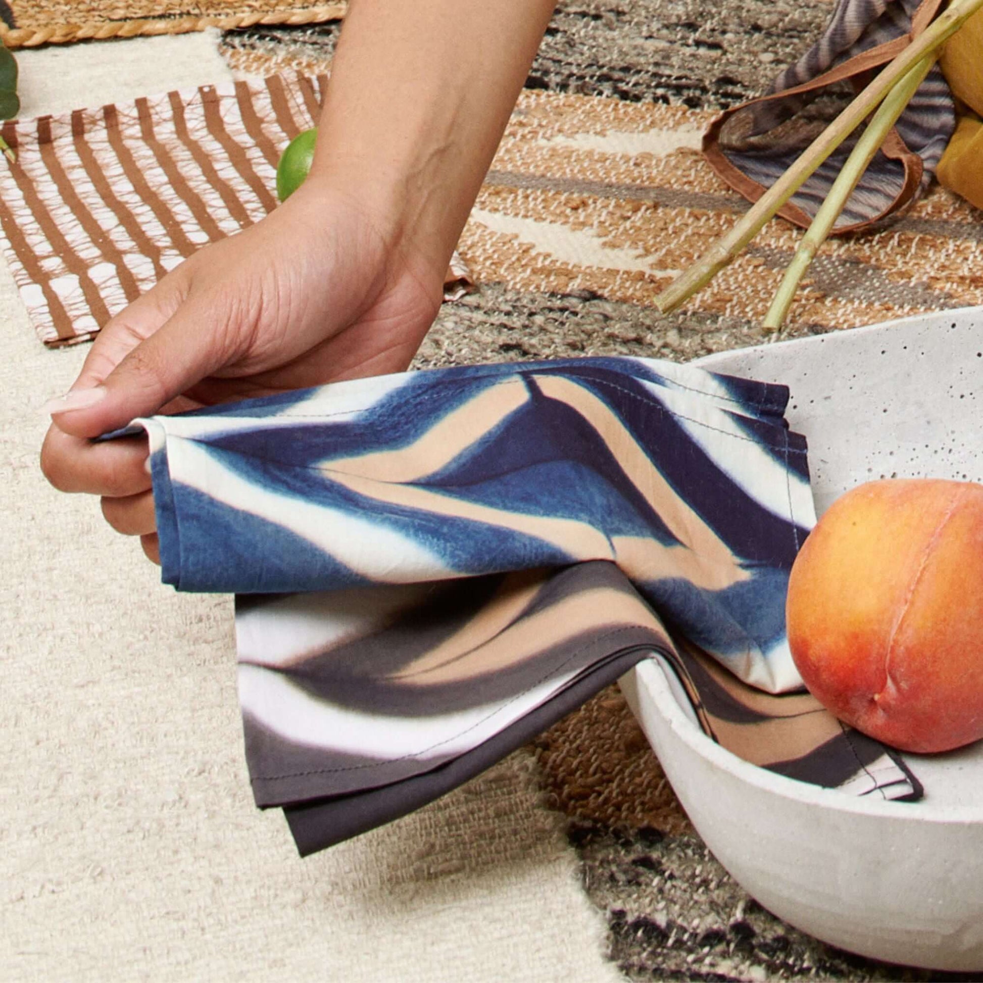Tisa Indigo Hand Crafted Shibori Print Cotton Table Napkin set of 4 elegantly displayed with a bowl of fruit.