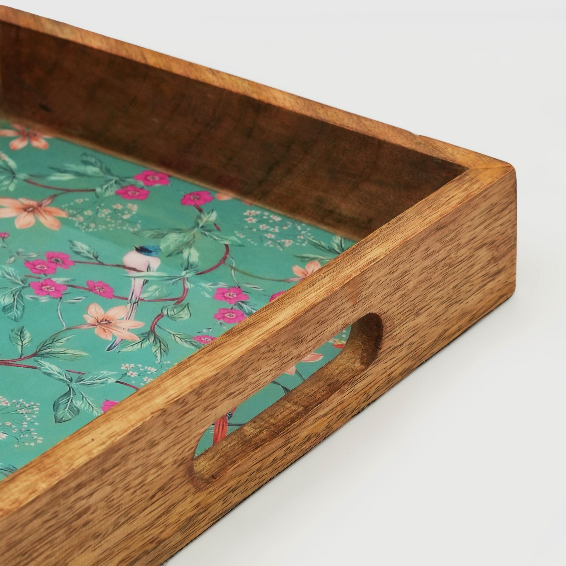  Close-up of the smooth mango wood joints and glossy enamel floral pattern on the inlay tray.