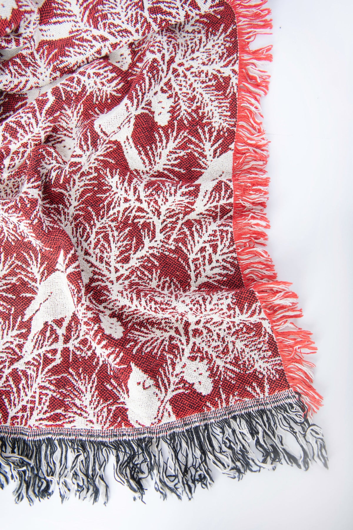 Close-up of the darker reverse side of the Cherie Cranberry cardinal and pine woven throw