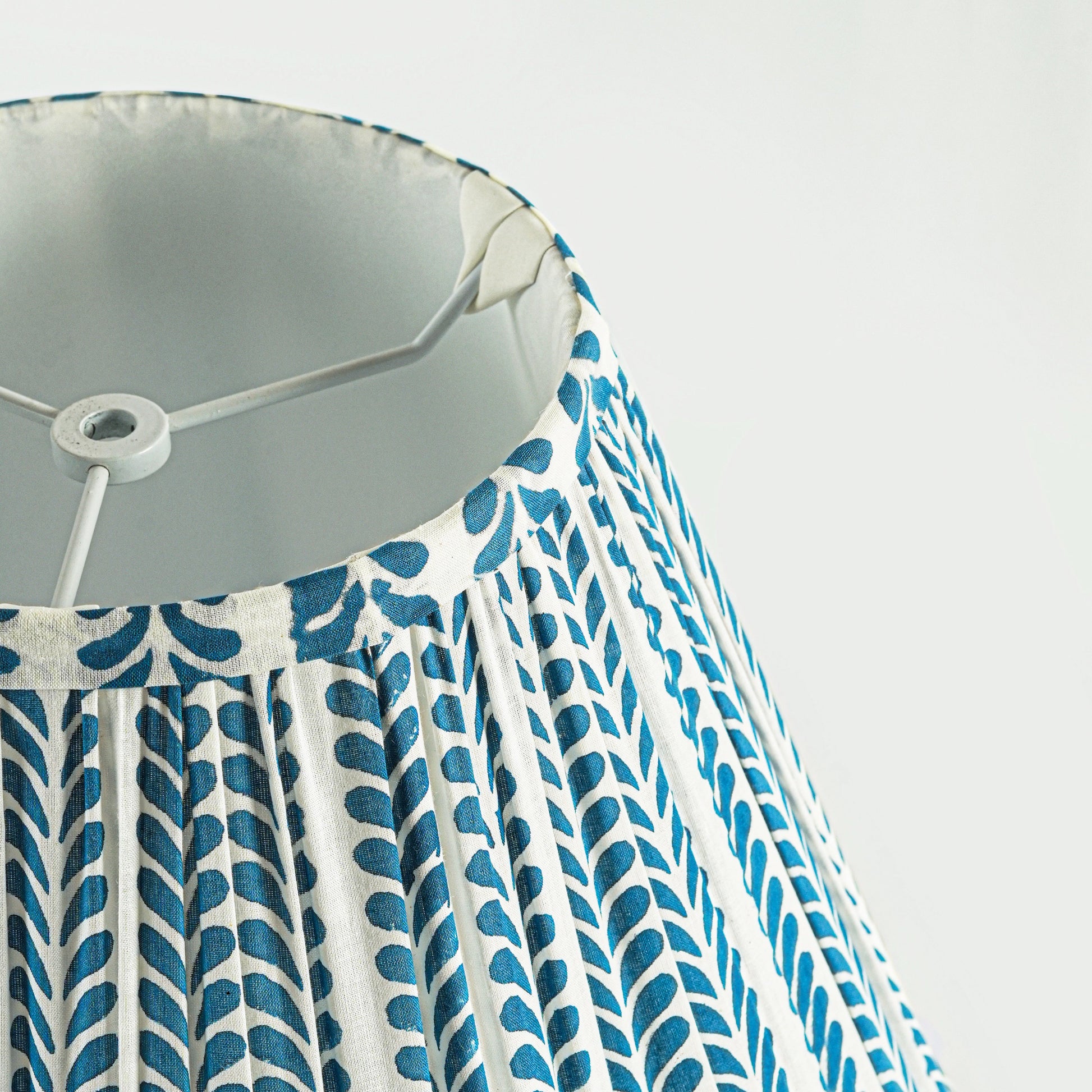 Close-up of a lampshade with blue and white pattern on a light gray background