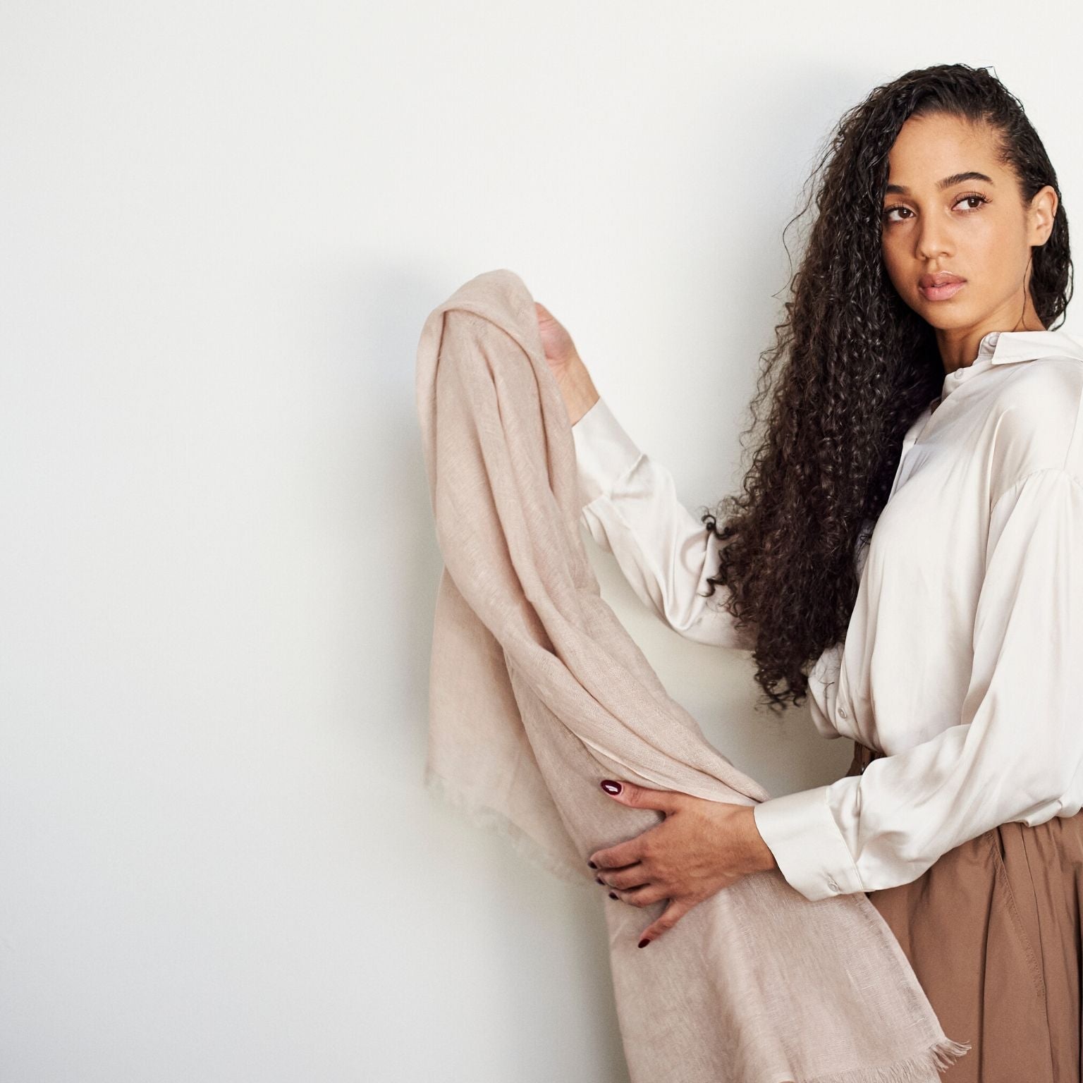 Oat Beige Neutral Hand Woven Soft Linen Silk Scarf held elegantly by a model, showcasing its soft texture and color.