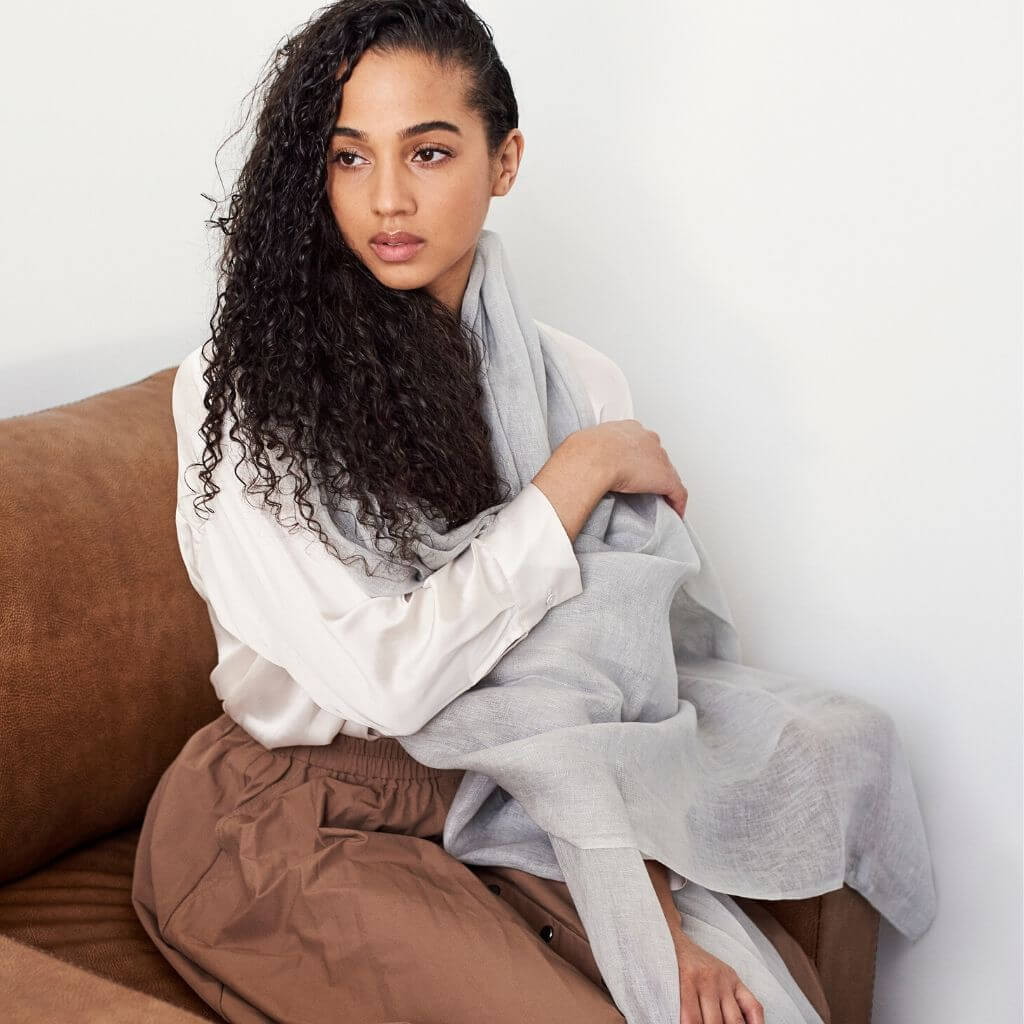 Model wearing a Pebble Light Gray Hand Woven Soft Linen Scarf, showcasing its elegance and versatility.