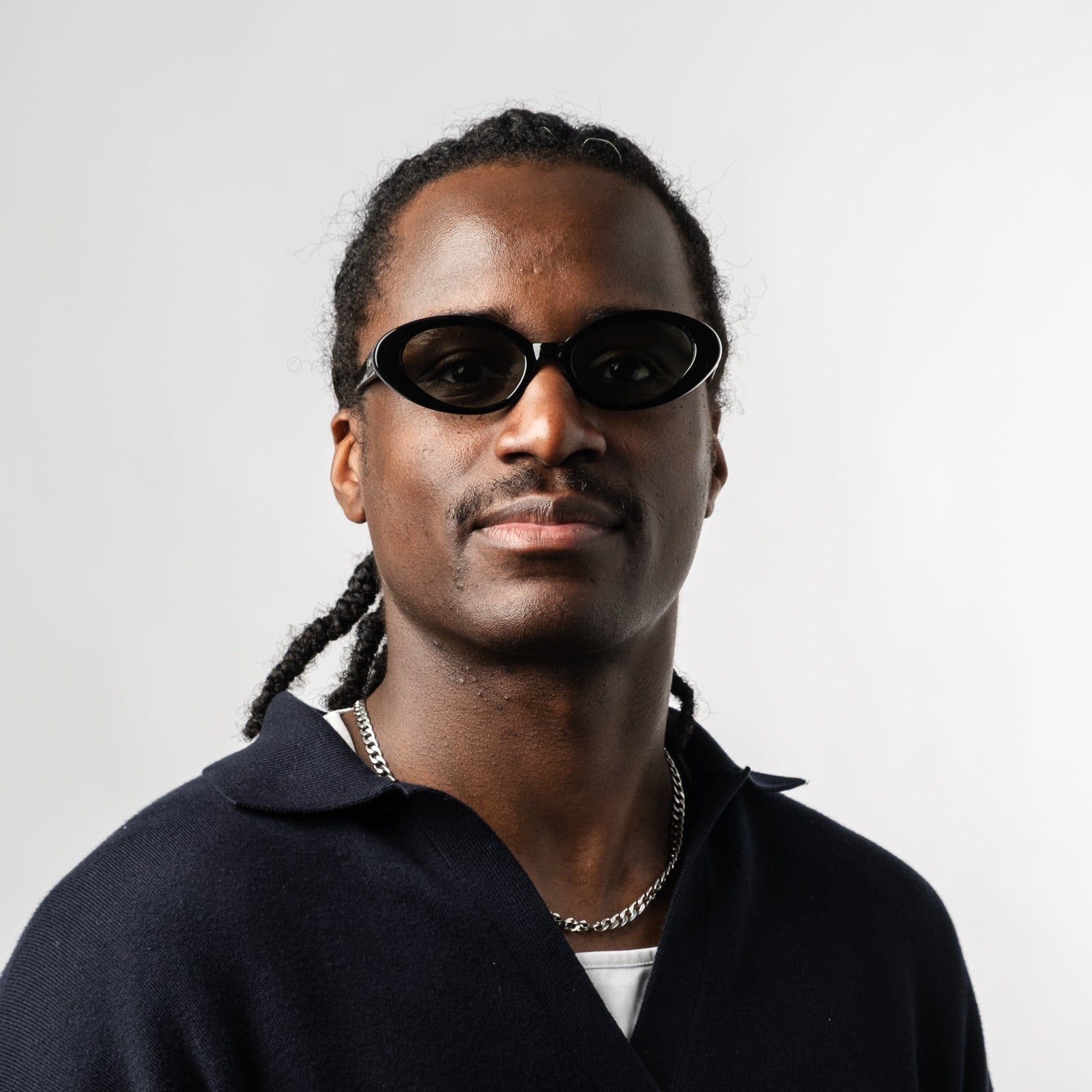 Male wearing Sad Eyewear Bloom oval sunglasses in black with tinted olive lenses