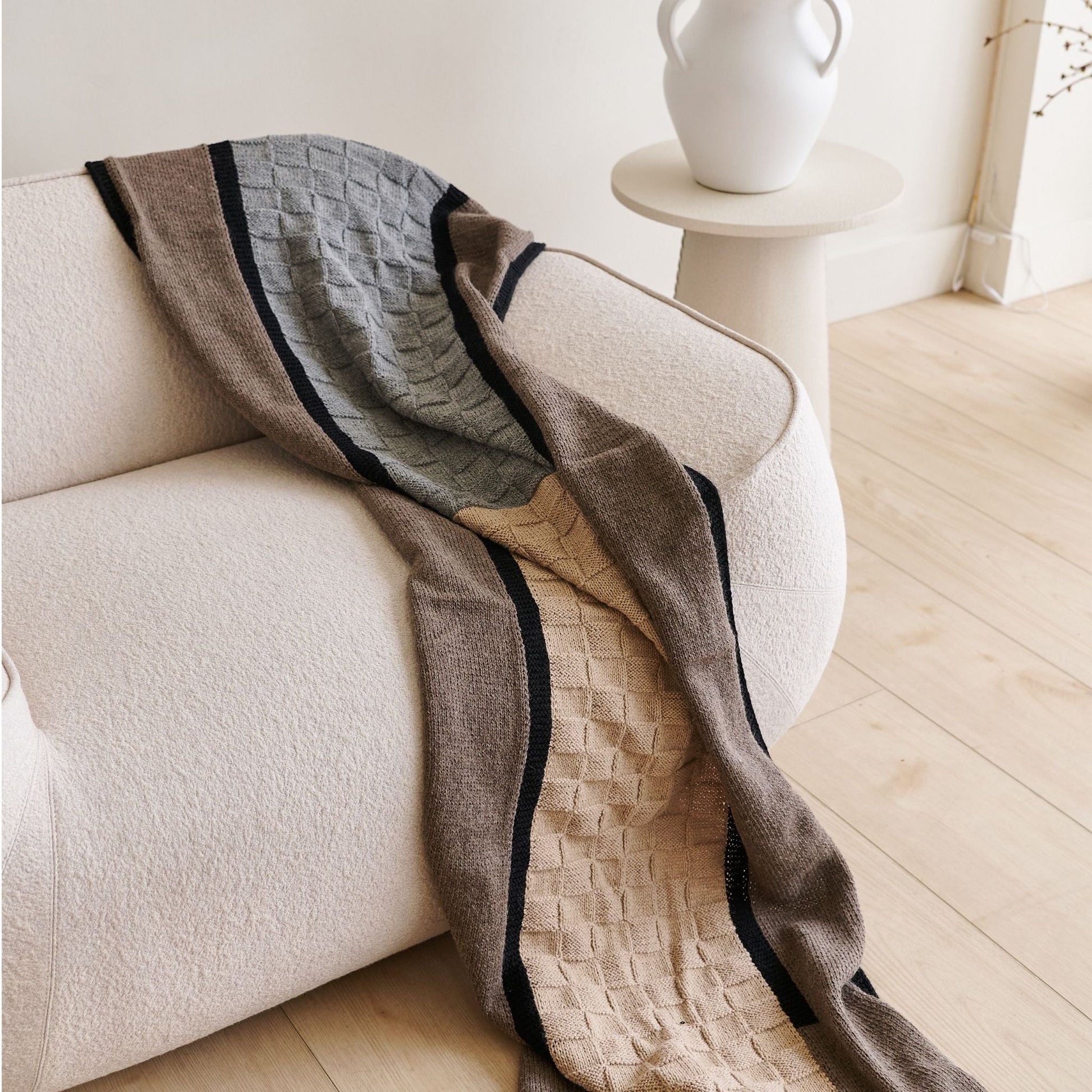 Muhu Brown Gray Hand Knitted Peruvian Alpaca Blanket / Large Plush Scarf draped over a cozy sofa.