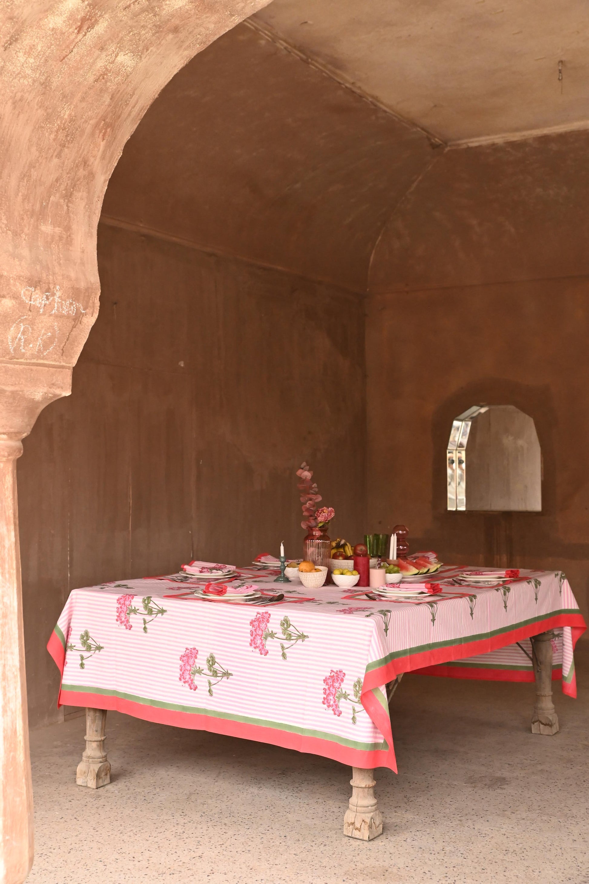 Pink hydrangea blockprint tablecloth set for outdoor dining under stone arch