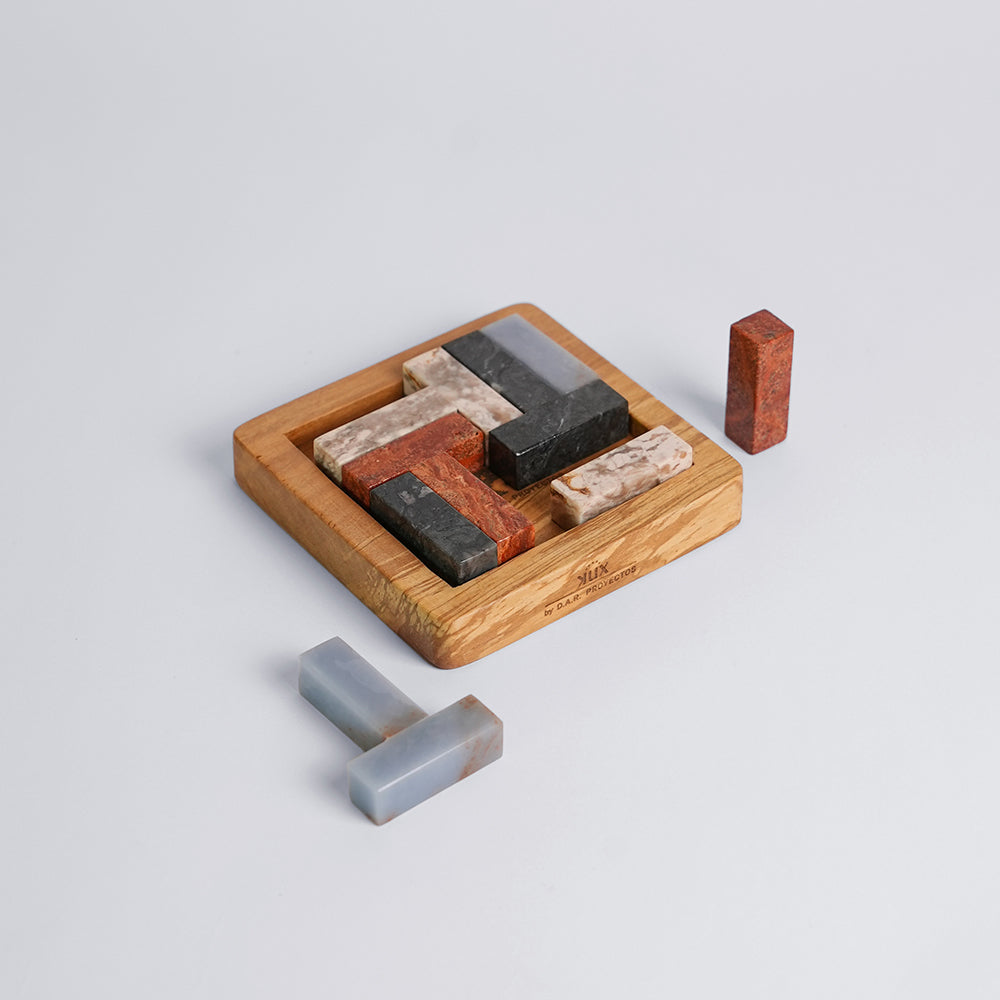 Angled view of the solid Tetris gemstone puzzle revealing its interlocking multi-colored stone blocks on a white background.