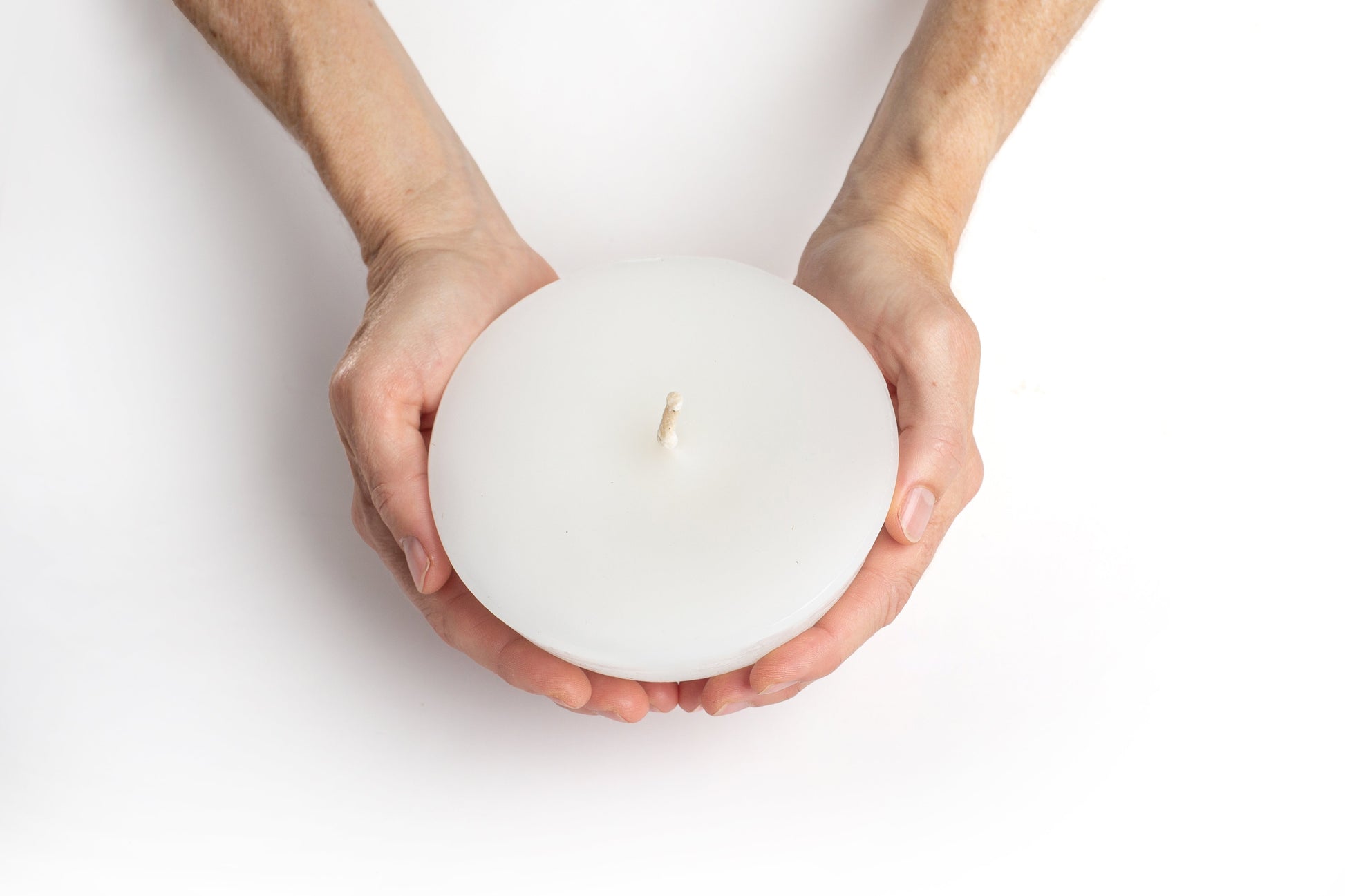 Hands holding a Luma Afrika Outdoor Bowl candle 5" width that shows that it sits in the palms.  Infused with citronella & lavender to repell inscects.  
